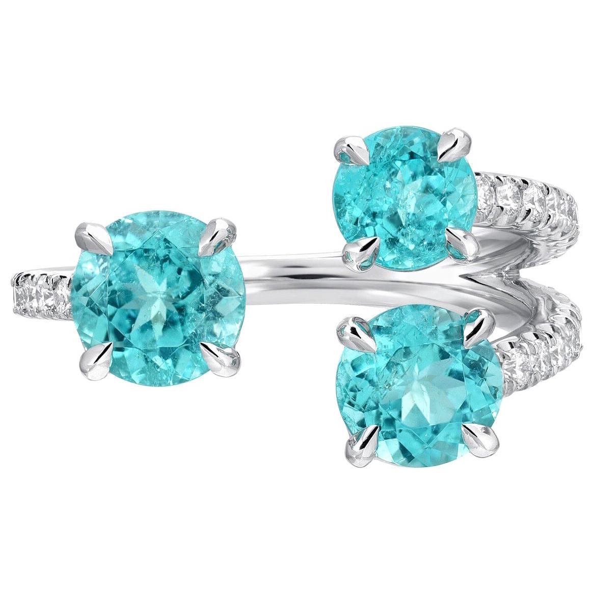 Immensely rare trio, of Brazilian Paraiba Tourmaline rounds, weighing a total of 2.08 carats, are hand set in this dainty and classy platinum cocktail ring, adorned by a total of 0.51 carats of round brilliant diamonds.
AGL certificates are