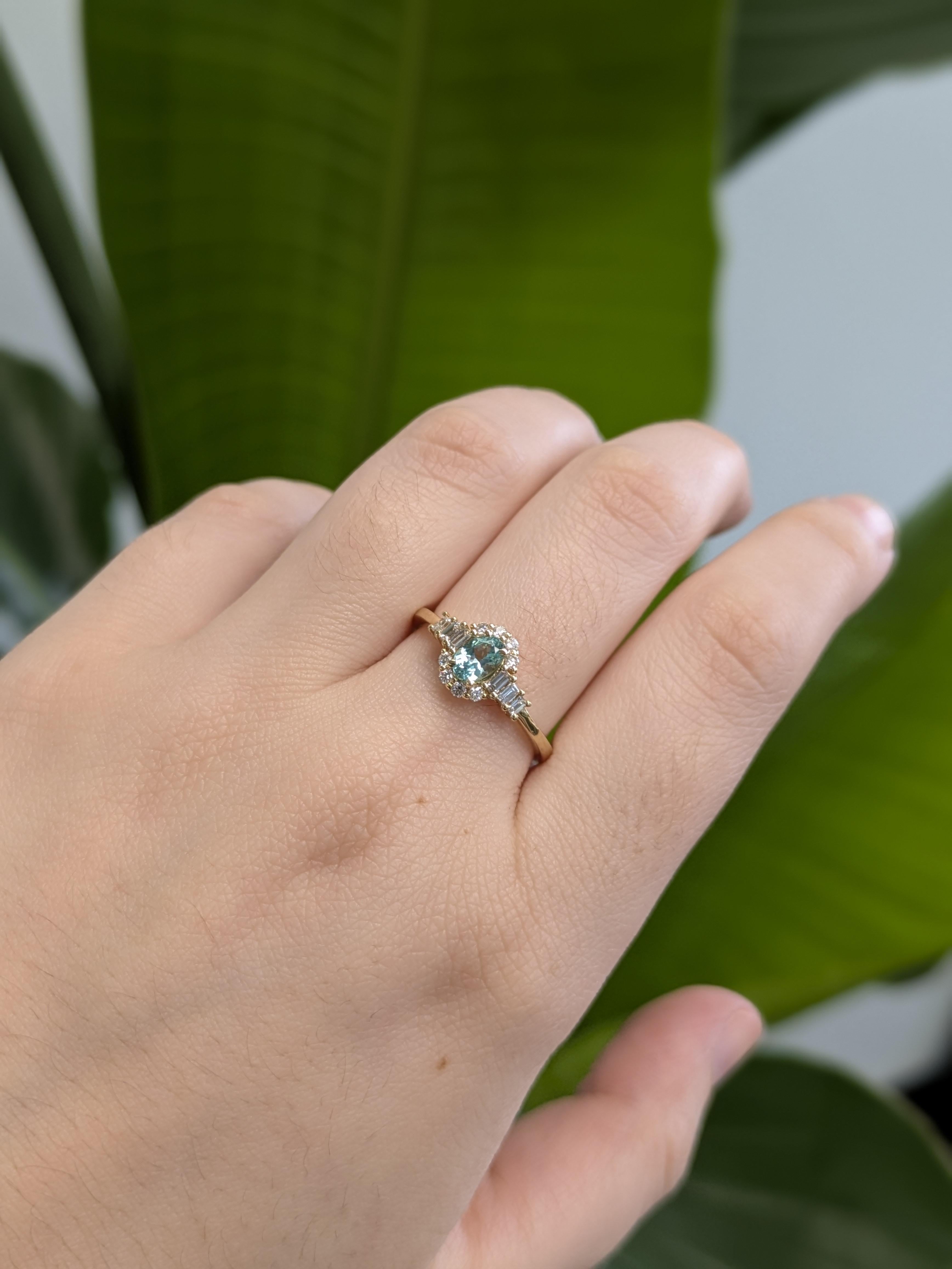 Experimenta el raro resplandor de una turmalina Paraiba brasileña de 0,36 quilates, una gema azul verdoso eléctrico que parece contener la energía del propio océano. Engarzada en cálido oro amarillo de 14k y enmarcada por un halo de brillantes