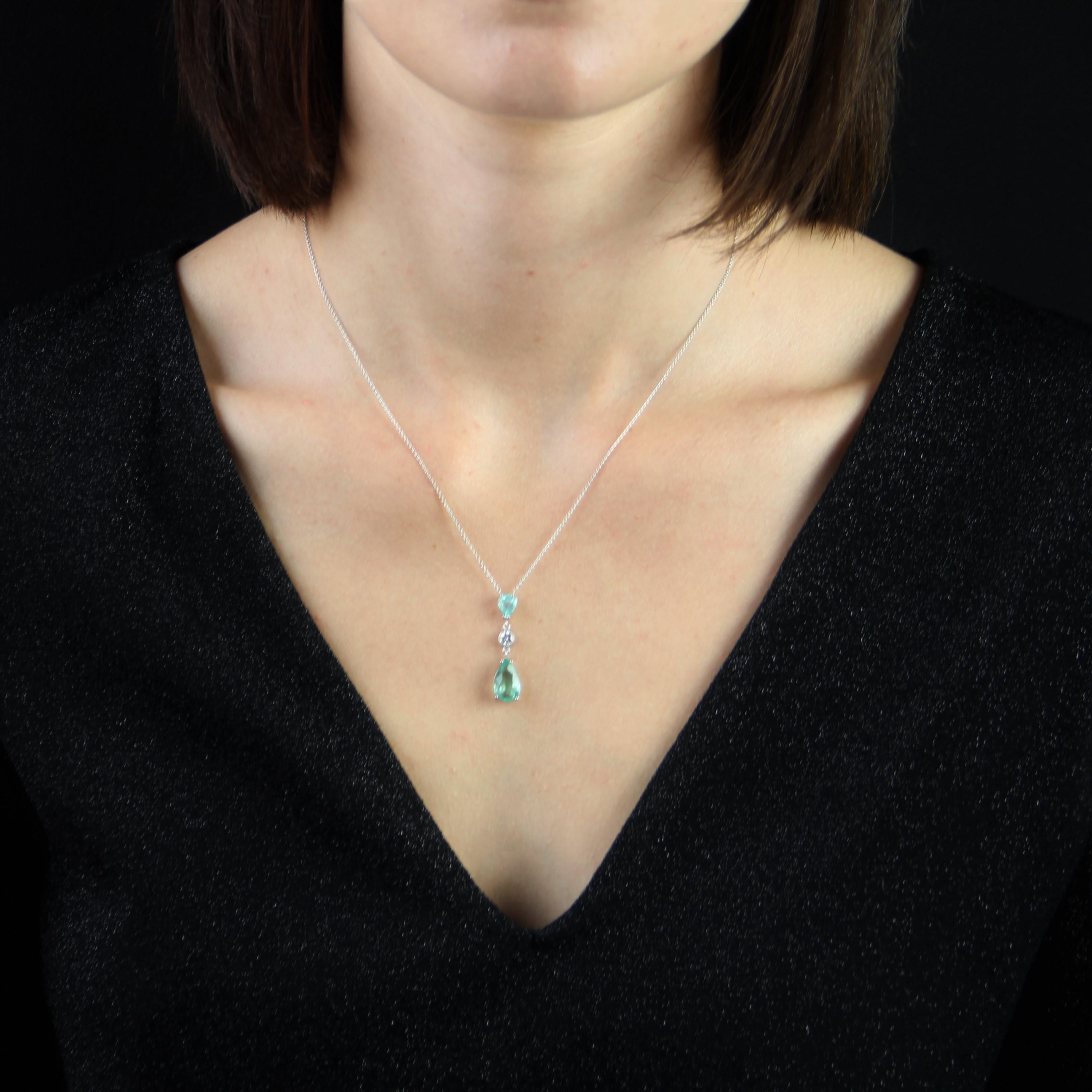  Baume creation - Unique piece.
Pendant in 18 karat white gold.
This modern pendant is made of a thin chain which holds on the front a pendant made of two pear-shaped paraiba tourmalines separated by a modern brilliant-cut diamond closed set in a