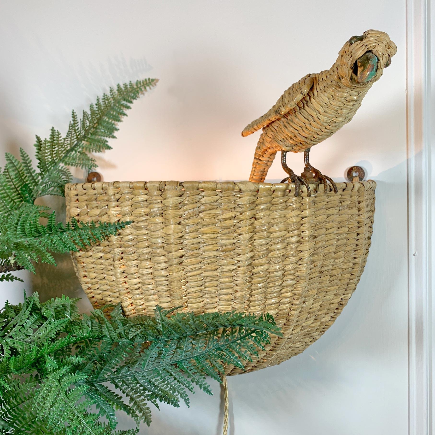 A beautiful hand woven chuspata wall light by Mario Lopez Torres, in the form of a parakeet perched on the side of a woven basket. Torres works are much sought after by interior designers across the globe, and these original vintage pieces are