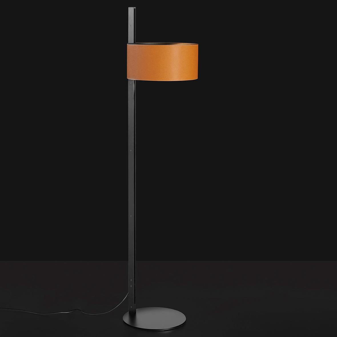 Die von Victor Vasilev entworfene Stehleuchte Parallele besteht aus einem zylindrischen Lampenschirm aus Metall, der von einem seitlich angeordneten vertikalen Stiel getragen wird. Der Stiel besteht aus zwei mattschwarzen Metallplatten, die im