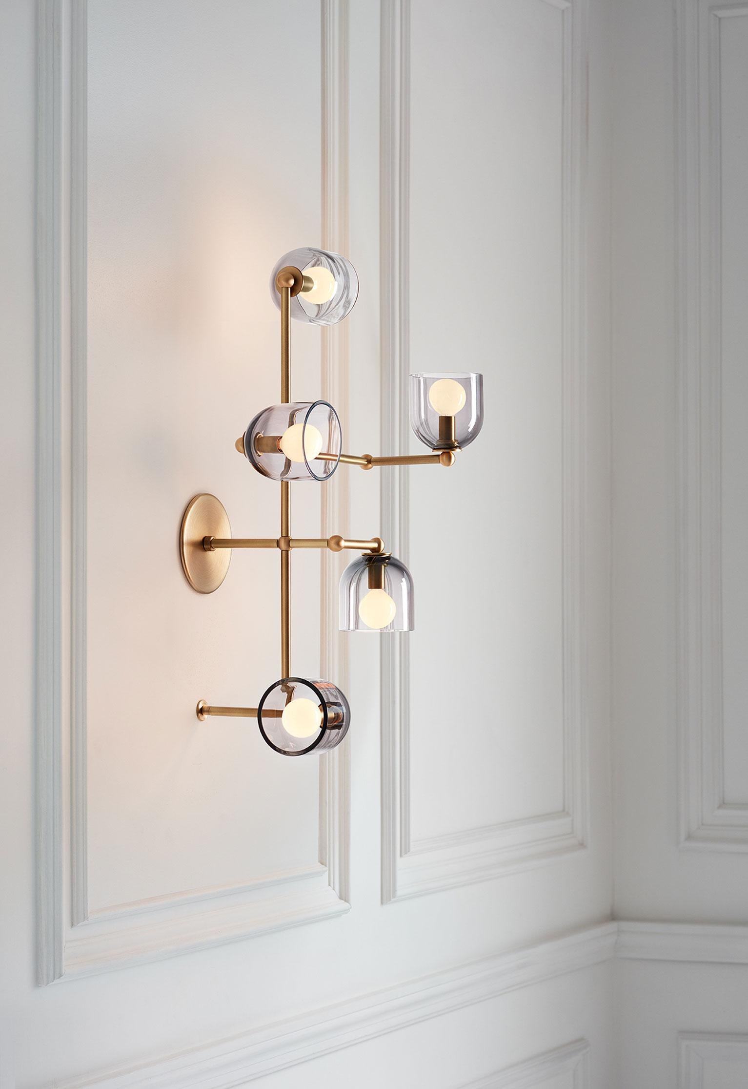Glass vessels extend gracefully on a brass framework.

Parallel elevates the scale and presence of the wall sconce. It has enough personality to substitute for an art piece while retaining all the functionality of a sconce.

Parallel can be used