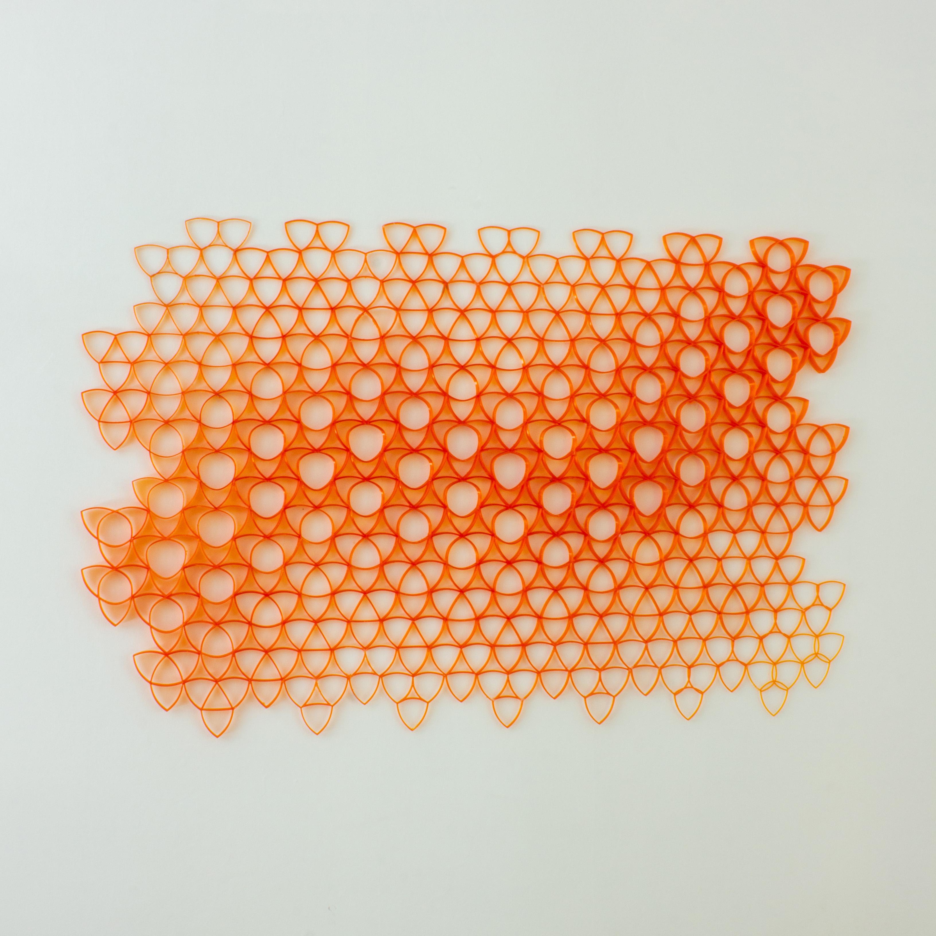 Parametric wall art, made from over 100 plastic PET bottles. 120 x 90 cm. (47 in x 35 in). The design follows a triangular geometric pattern that changes in scale proportionally as it traces a curved path. The pattern is 3D printed and meticulously