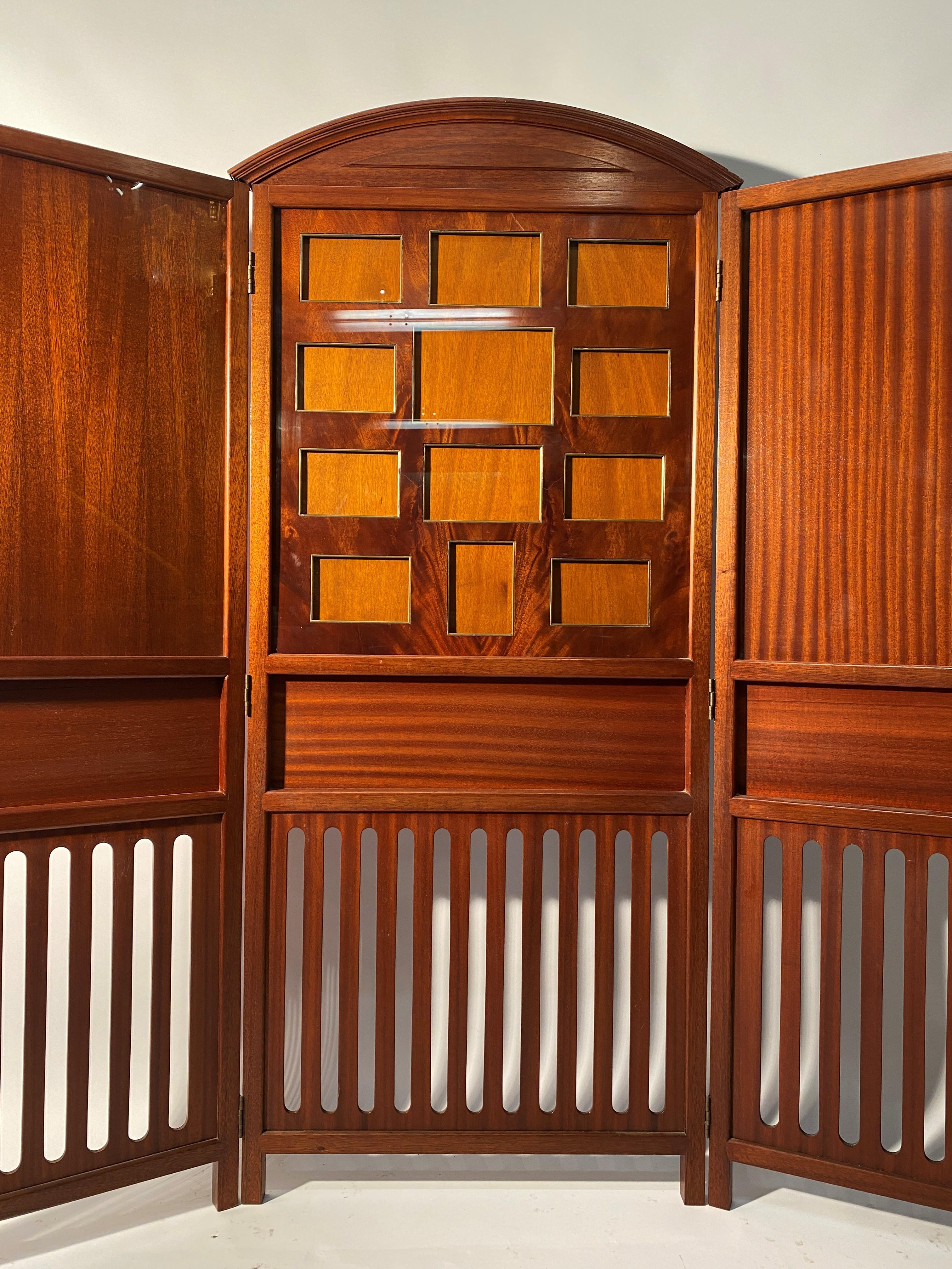 Rare neoclassical style mahogany screen by Madeleine Castaing. It opens with three articulated shutters:
 Measures: The central : height 162.3 cm width 68.2 cm
The side : height 149.5cm width 48.5cm
The central part is adorned with photo doors