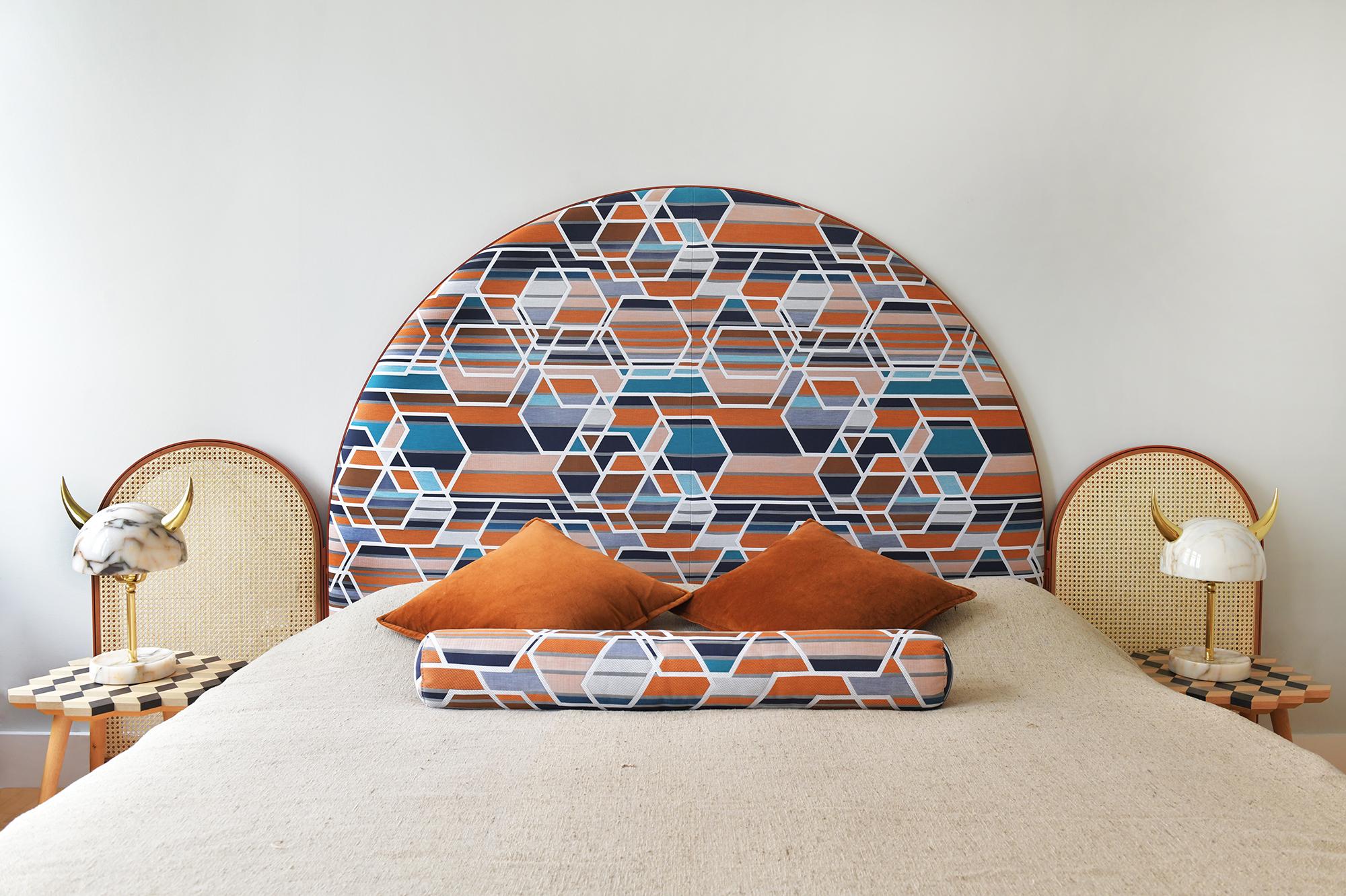 “Paravent Ideal” is a handcrafted, screen headboard made by artisans in Turkey, preserving and sustaining traditional Turkish handcrafts. The central large arc is upholstered in Maharam geometric fabric Agency, which has hues of burnt orange, blues
