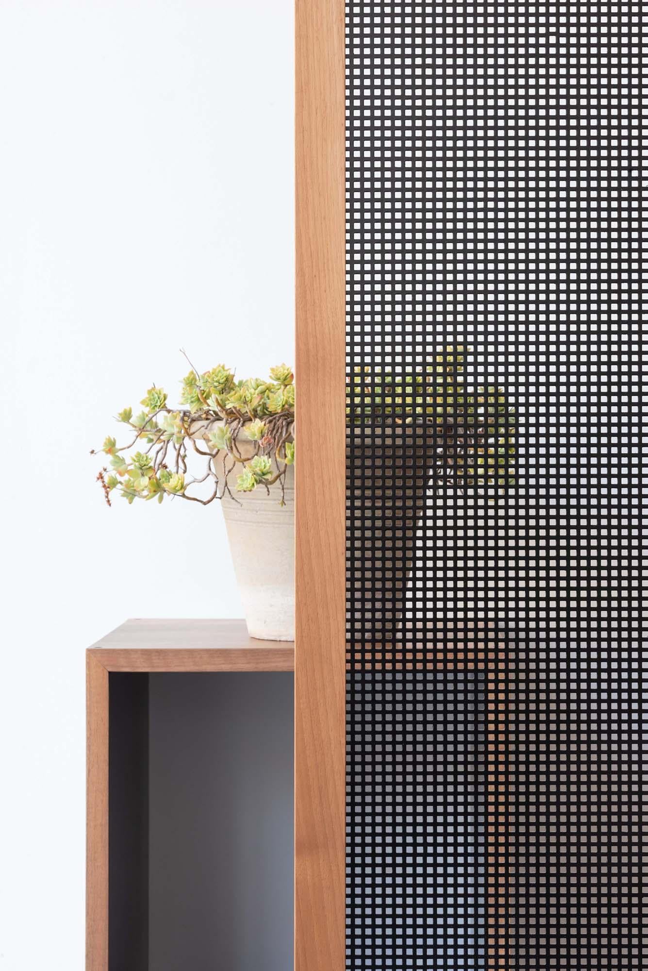 Four rectangular doors in walnut and perforated sheet shield spaces drawing light and dark suggestions.
Intuit, grasp the forms, which beyond the screen are defined in space.
A thin membrane in perforated iron, which hides and exalts, helping the