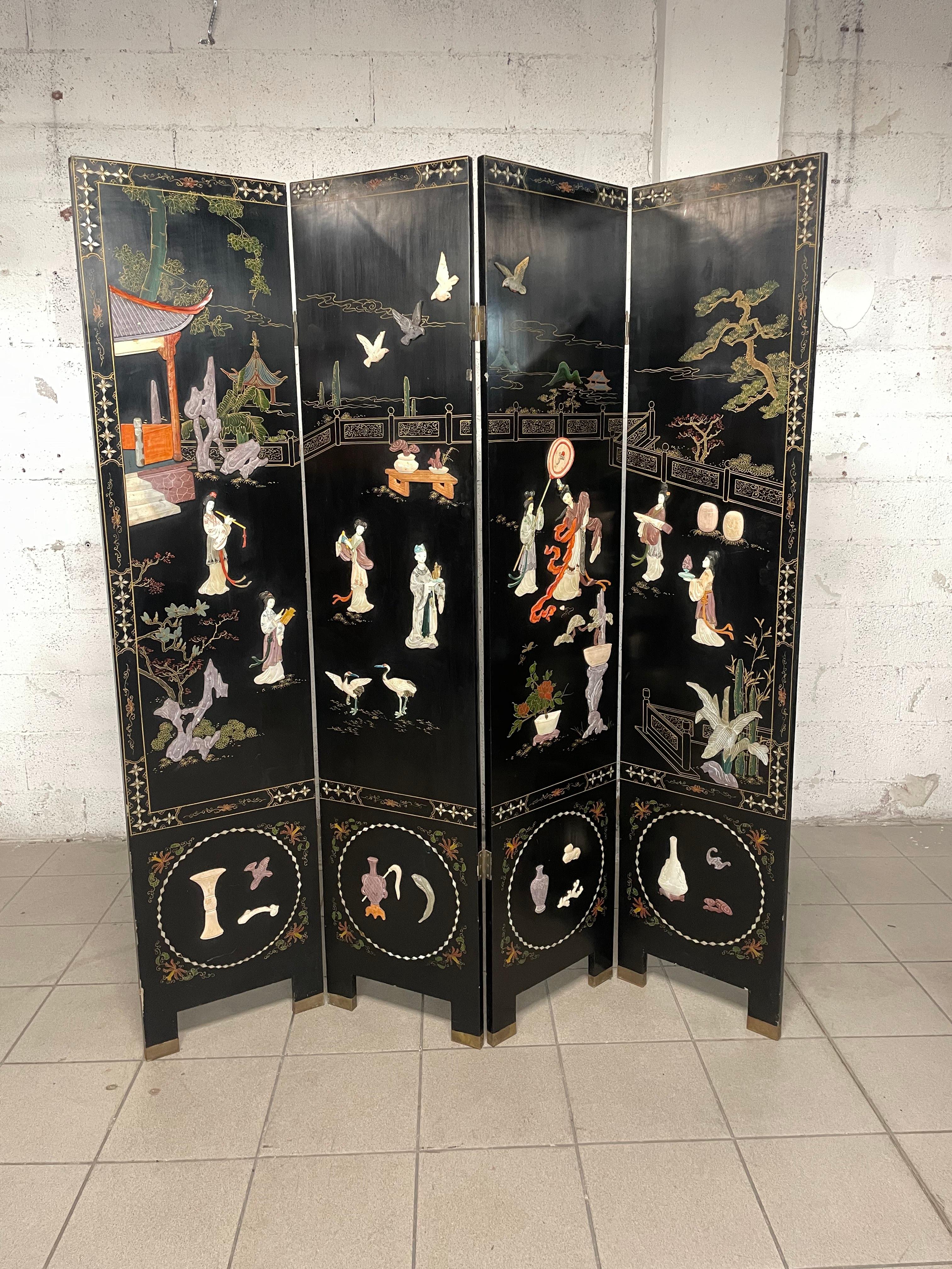 Eleganter Paravent aus lackiertem Holz und Chinoiserie-Dekor aus Speckstein aus der ersten Hälfte des 20. Jahrhunderts.

Perlmuttintarsien und Messingdetails.

Der Zustand der Leinwand ist gut, obwohl der Lack an einigen Stellen etwas abgeblättert