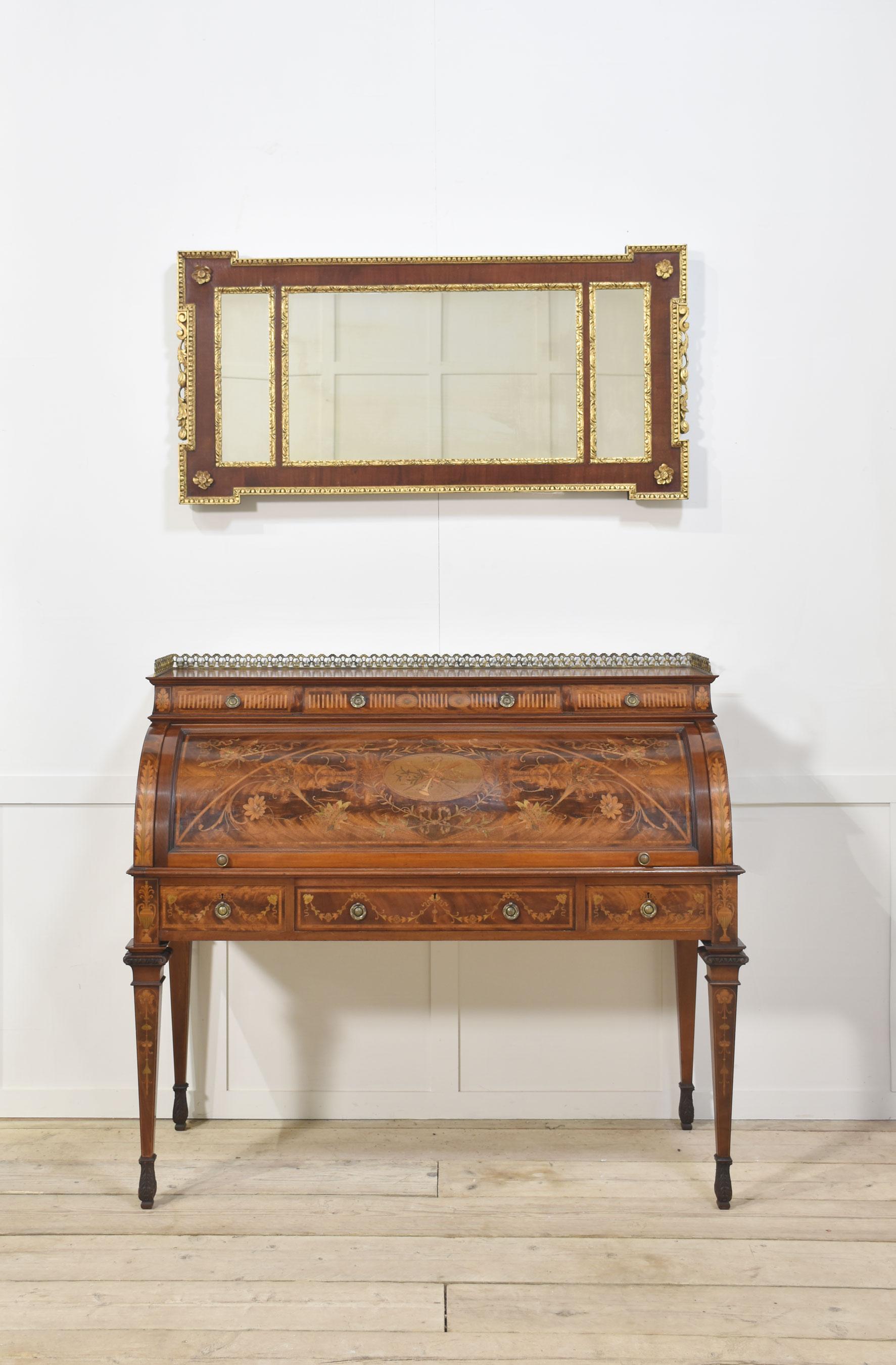 Parcel-gilt mahogany shaped rectangular three-plate mirror, the frame bordered overall with egg-and-dart moulding, the mirror plates framed with stylised foliate borders, each hipped angle applied with a flowerhead, the sides applied with S-scrolls,