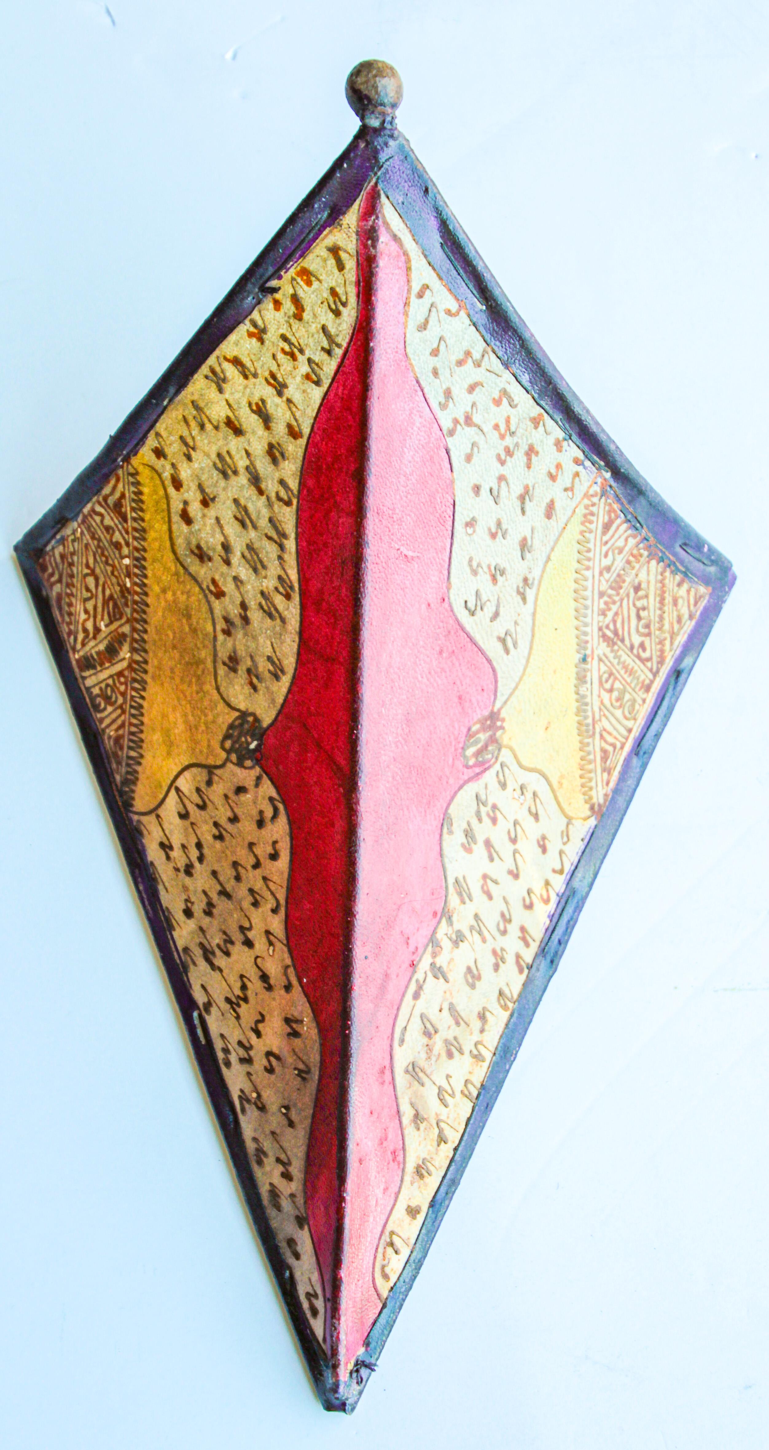 Afrikanische Stammeskunst Pergament Wandleuchte mit einer großen Dreiecksform aus Leder auf Eisen genäht und handbemalt Oberfläche.
Diese Kunstwerke können als Lampenschirm für die Wand verwendet werden.
Der mit Pergament überzogene Eisenrahmen,