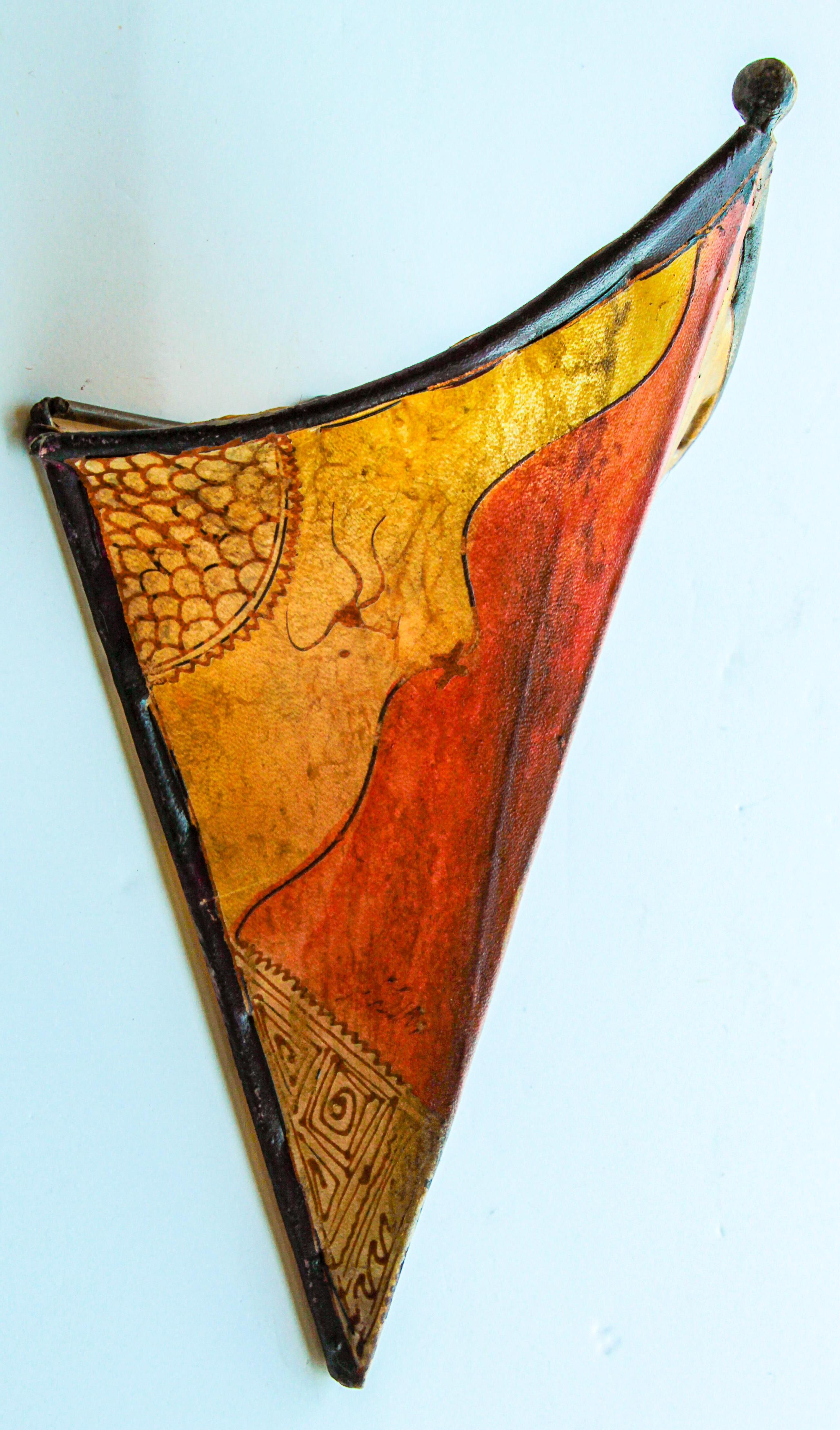 African Tribal Art parchment wall shade sconce featuring a large triangle hide form stitched on iron and hand painted surface.
These Moroccan art pieces could be used as wall lamp shade.
Iron frame covered with hide parchment which has been hand
