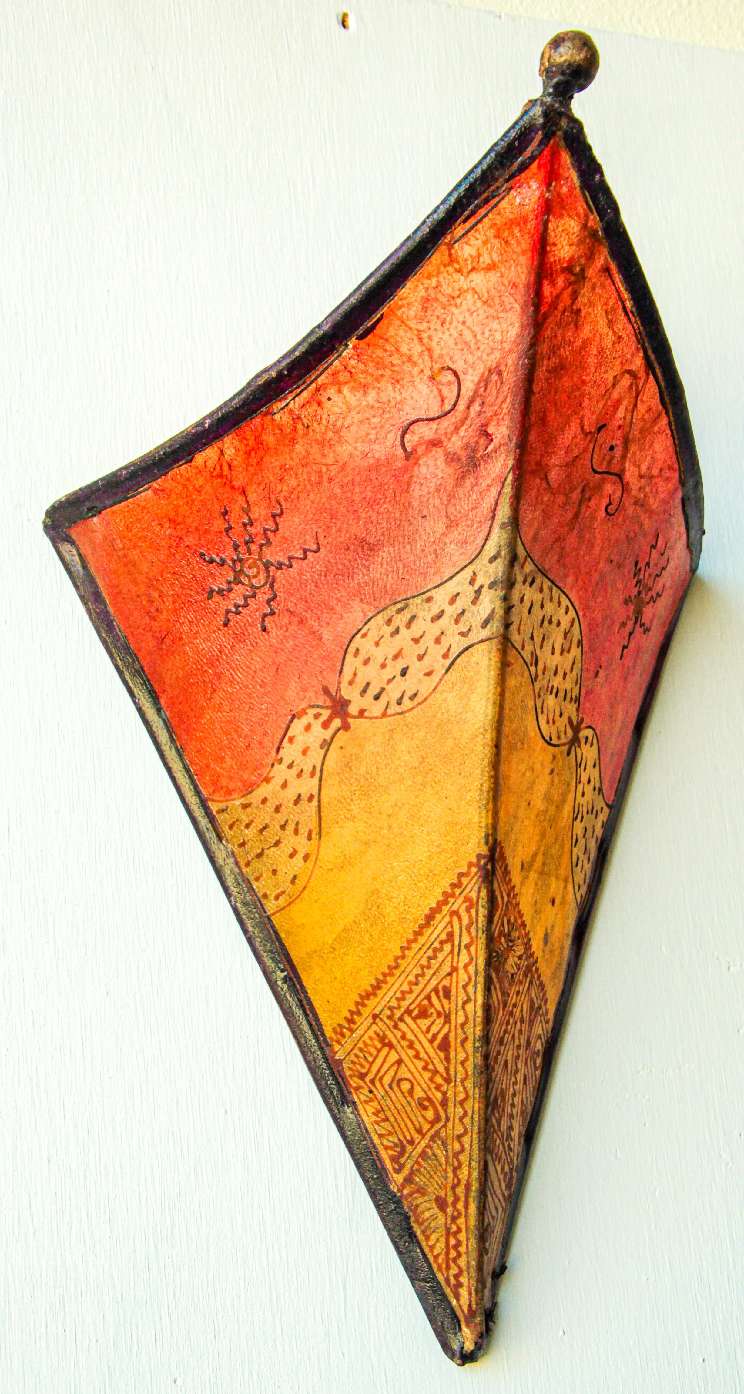 African Tribal Art parchment wall shade sconce featuring a large triangle hide form stitched on iron and hand painted surface.
These Moroccan Art pieces could be used as wall lamp shade.
Iron frame covered with hide parchment which has been