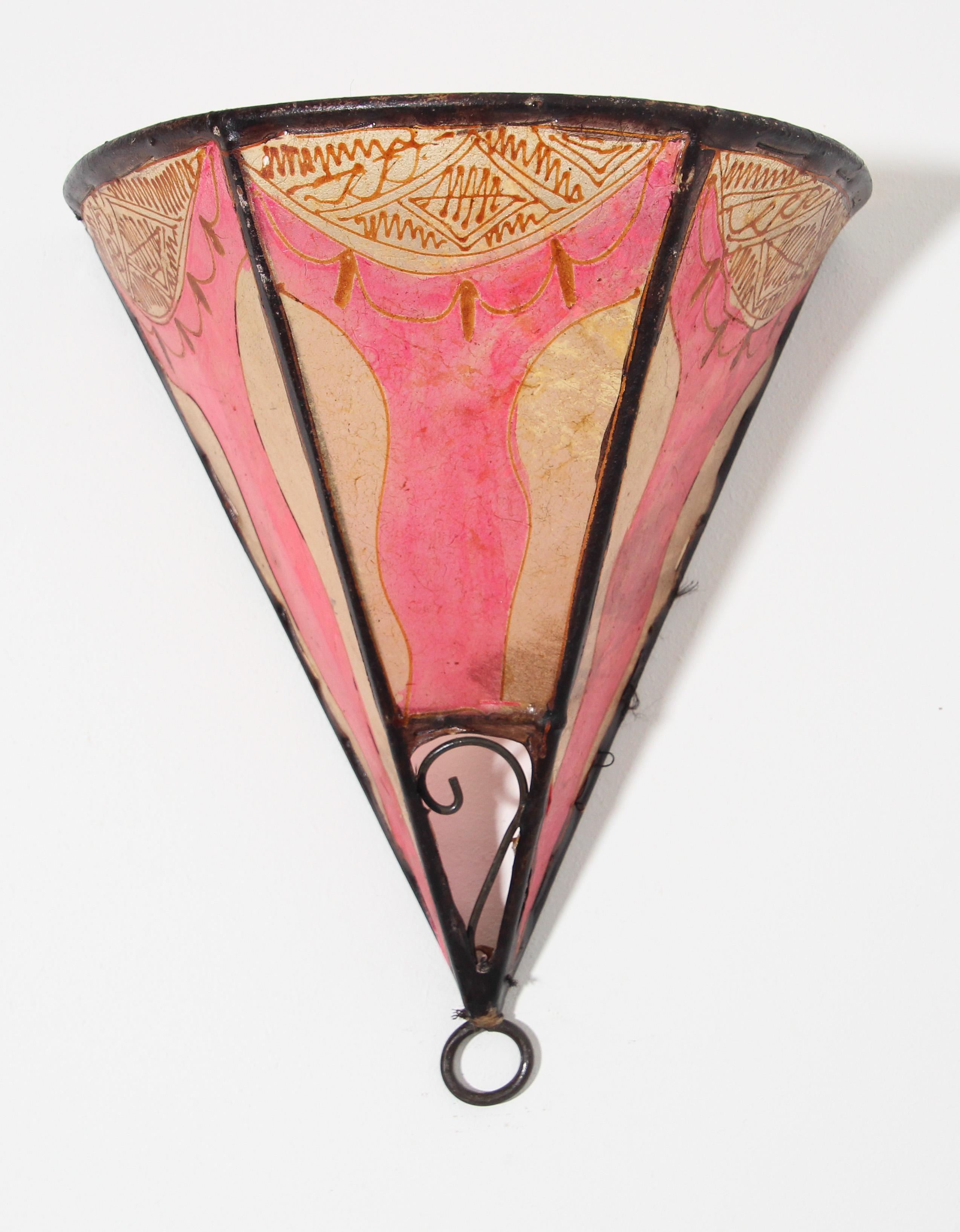 African tribal art parchment wall shade sconce featuring a large triangle hide form stitched on iron and hand painted surface.
These Moroccan art pieces could be used as wall lamp shade.
Iron frame covered with hide parchment which has been hand