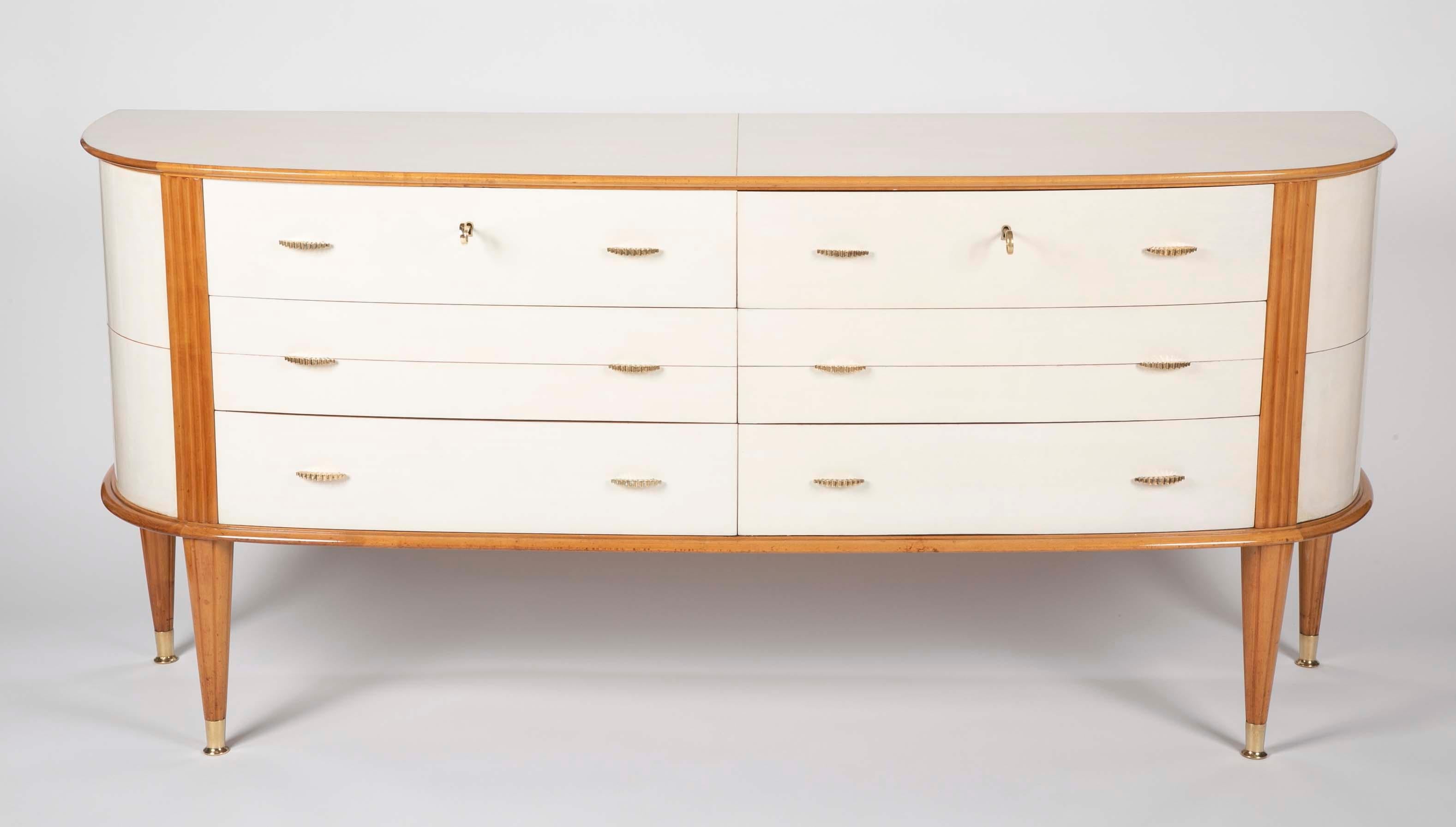A large Italian parchment chest of drawers rising on readed beech legs. The sides segmented in to quadrants with beechwood stringing.