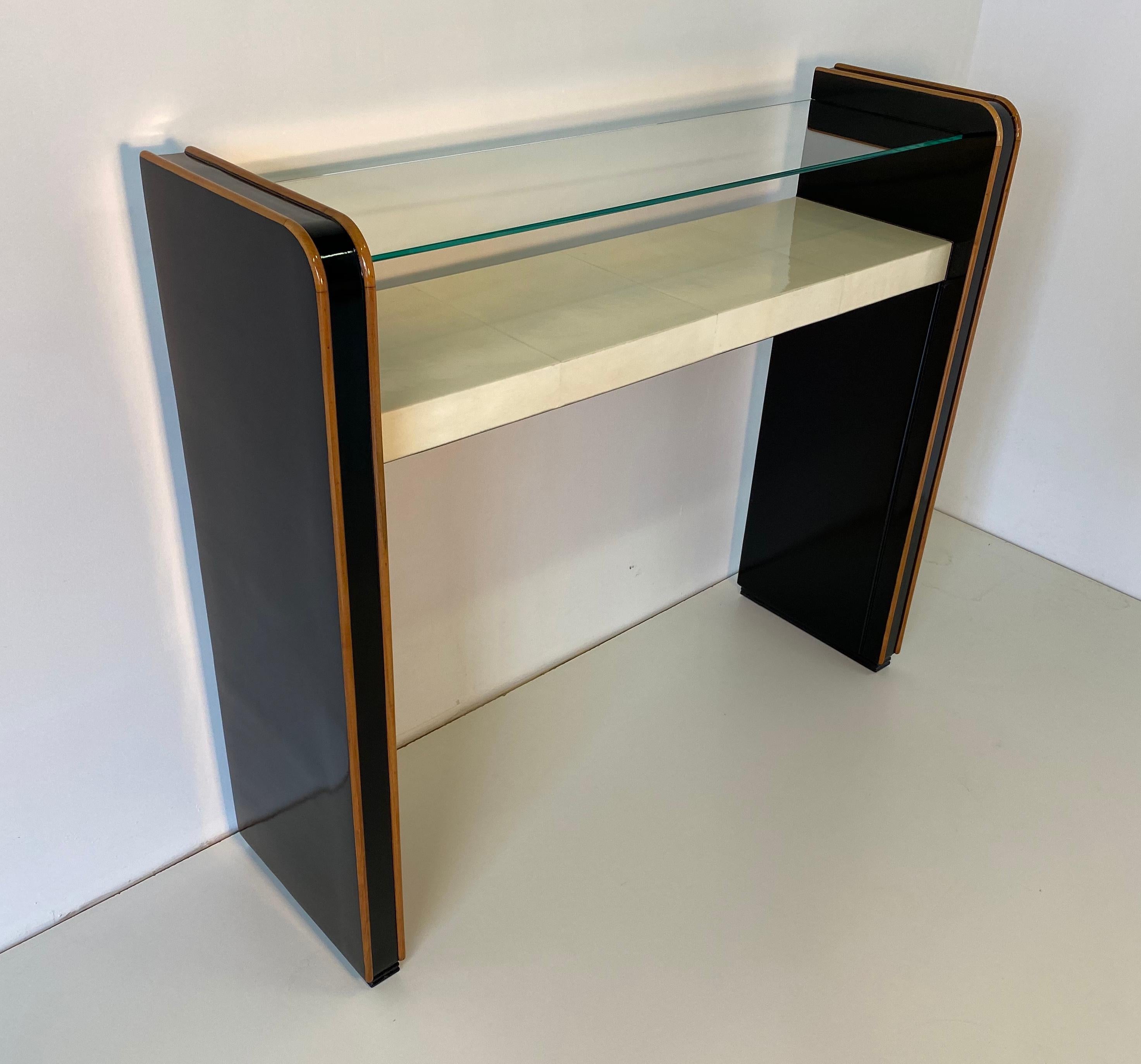 Rare Art Deco console from the 1940s produced in Italy, the top is in parchment while the structure is black lacquered with maple inserts and a glass shelf.
Completely restored.