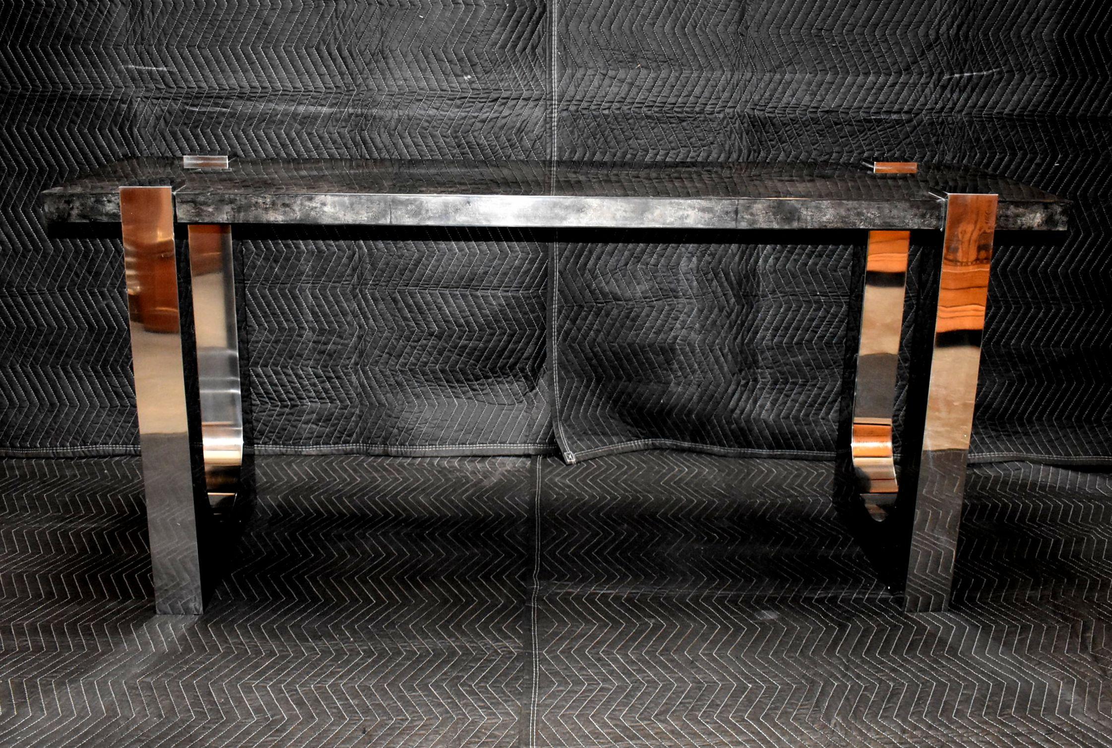 Console table cover with goatskin and stainless steel legs. Parchment is in varying shades of dark charcoal. (High gloss polyester resin filled finish).