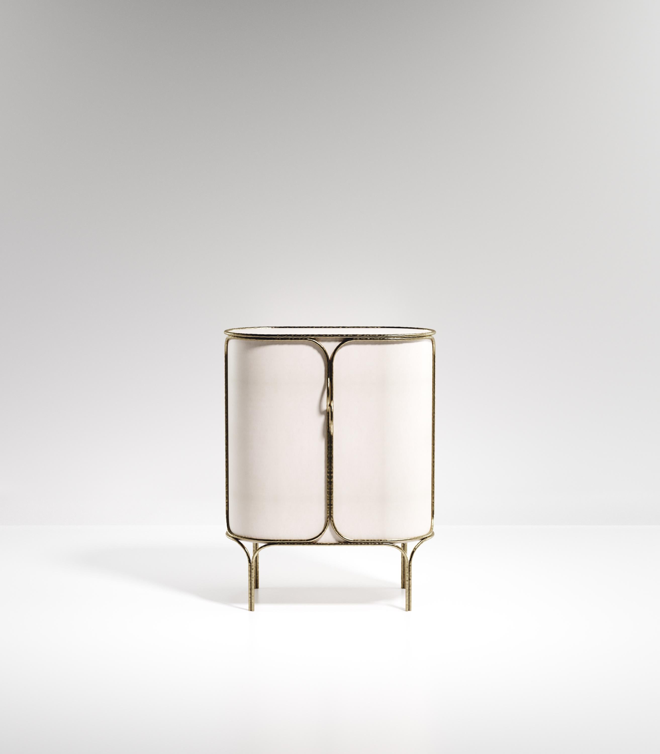 The Arianne bar cabinet by R&Y Augousti is one of a kind statement piece. The overall piece is inlaid in cream parchment accentuated with intricate bronze-patina brass details that have the signature Augousti 