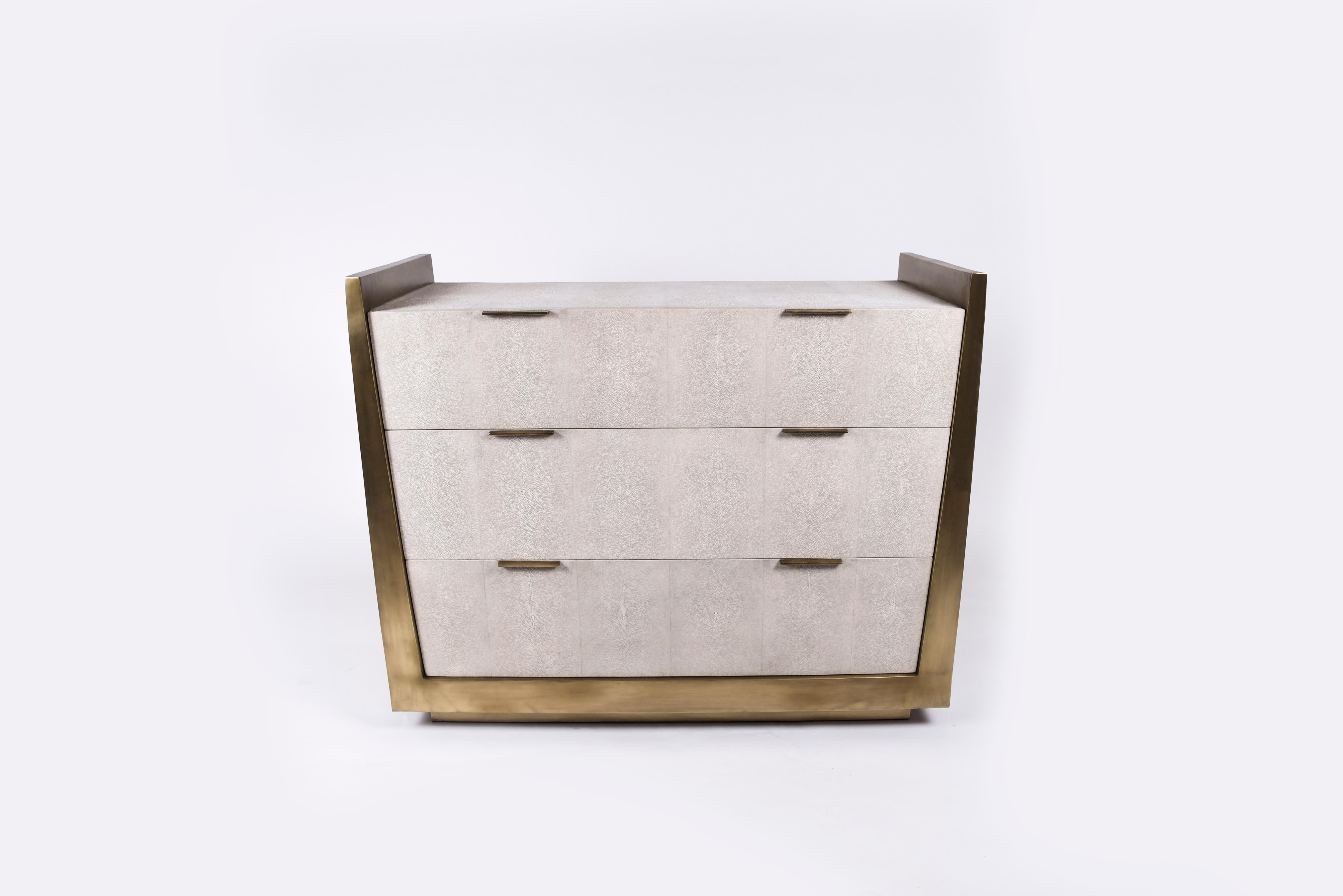 La commode Lola de R&Y Augousti est une pièce élégante avec sa géométrie subtile. Cette commode est entièrement incrustée de parchemin crème. La pièce est complétée par de discrètes poignées plates en laiton bronze-patiné pour les tiroirs. Les