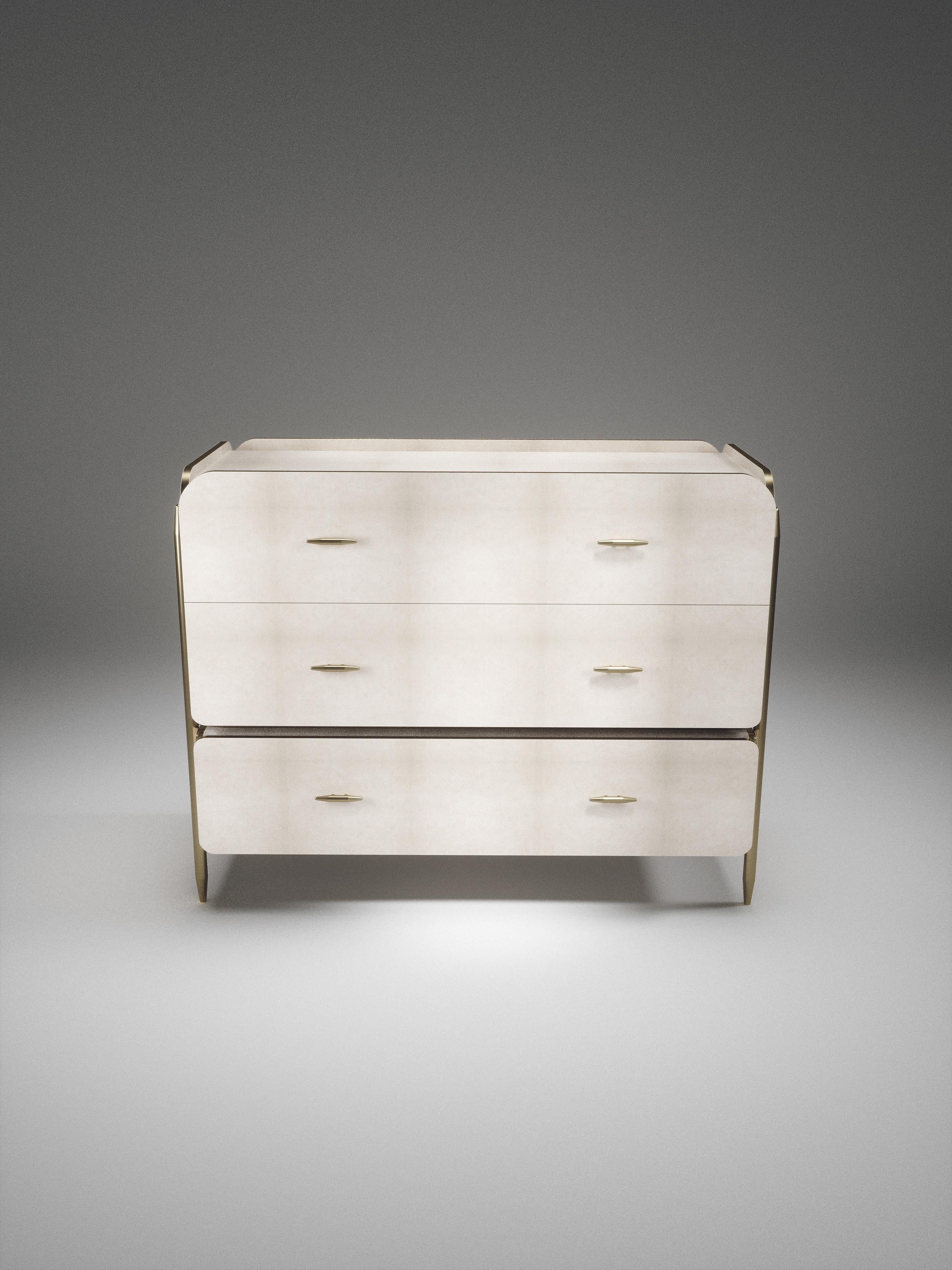 The Dandy rectangle chest of drawers by Kifu Paris is an elegant and a luxurious home accent, inlaid in cream parchment with bronze-patina brass details. This piece includes 3 drawers total and the interiors are inlaid in gemelina wood veneer. The