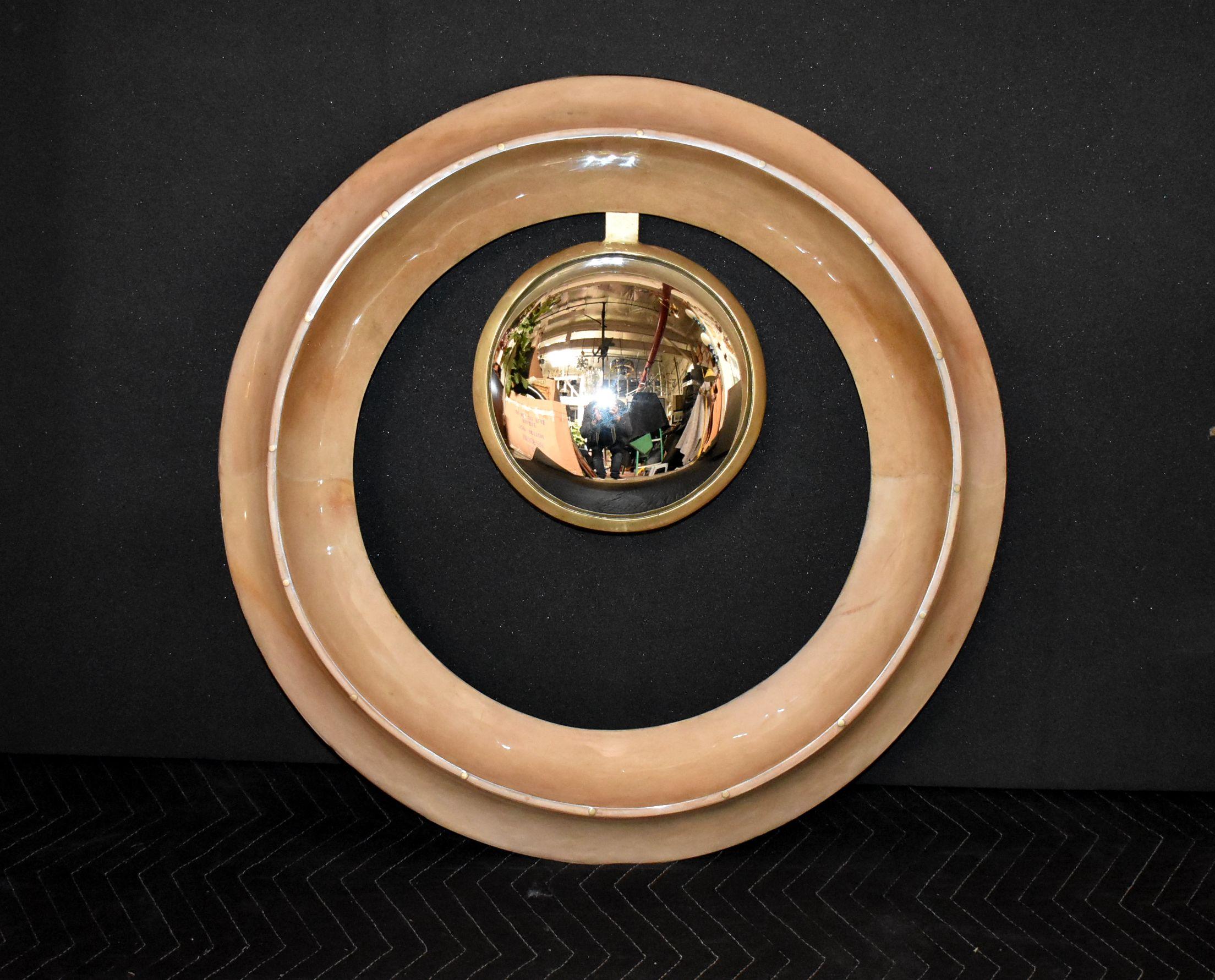 Round convex mirror cover with goatskin and brass details.
Parchment is in varying shades of natural color. (High gloss polyester resin filled finish).