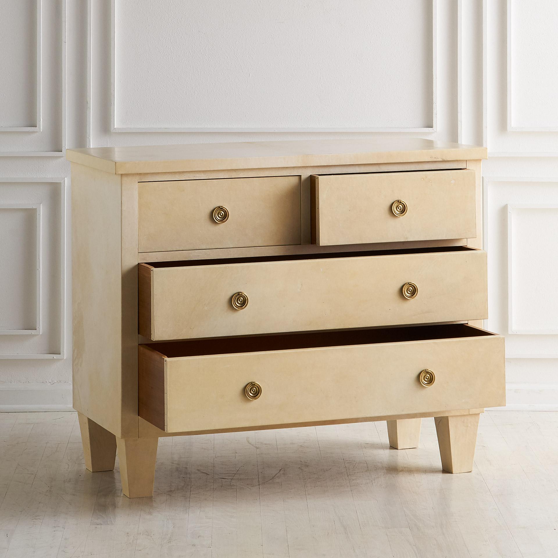 A four-drawer parchment-covered dresser featuring brass hardware. A fantastic piece for an entryway or bedroom. Gorgeous texture and finish throughout with generous storage.