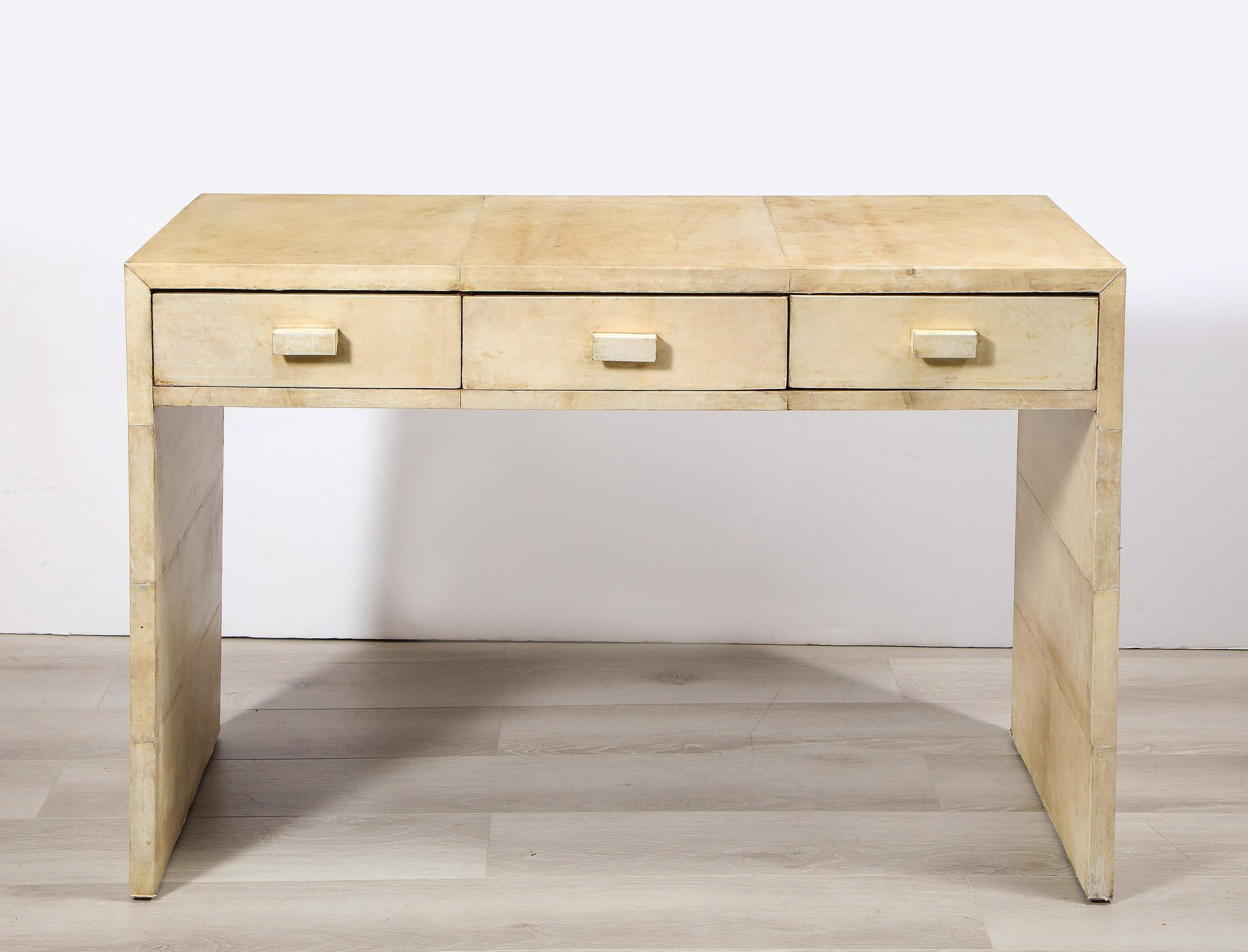 French parchment covered desk, in the manner of Jean-Michel Frank

The rectangular form all-over parchment covered desk with three drawers.