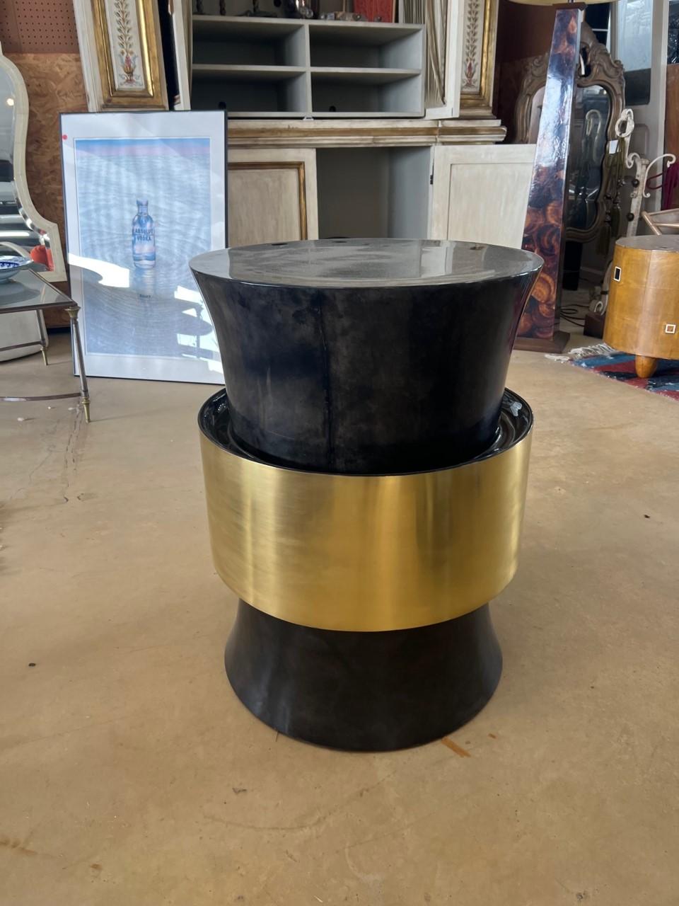 Elegant drum side table cover with goatskin.

Parchment is in varying shades of dark charcoal. 

(High gloss polyester resin filled finish)

Goatskin top coat polished high gloss

Color charcoal

Brass finish crystal coated.

