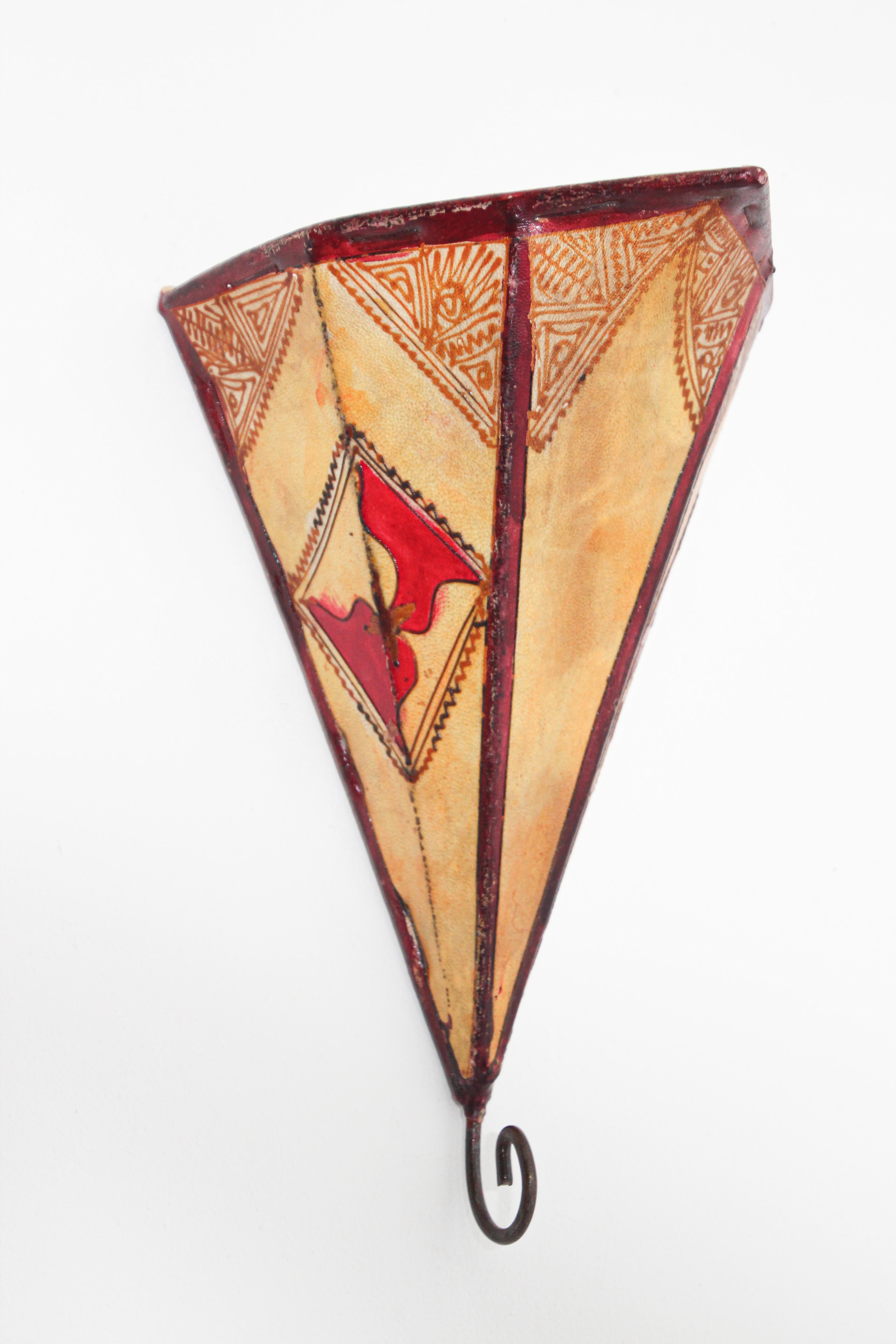 African tribal art parchment wall shade sconce featuring a large triangle hide form stitched on iron and hand painted surface.
These Moroccan art pieces could be used as wall lamp shade.
Iron frame covered with hide parchment which has been hand