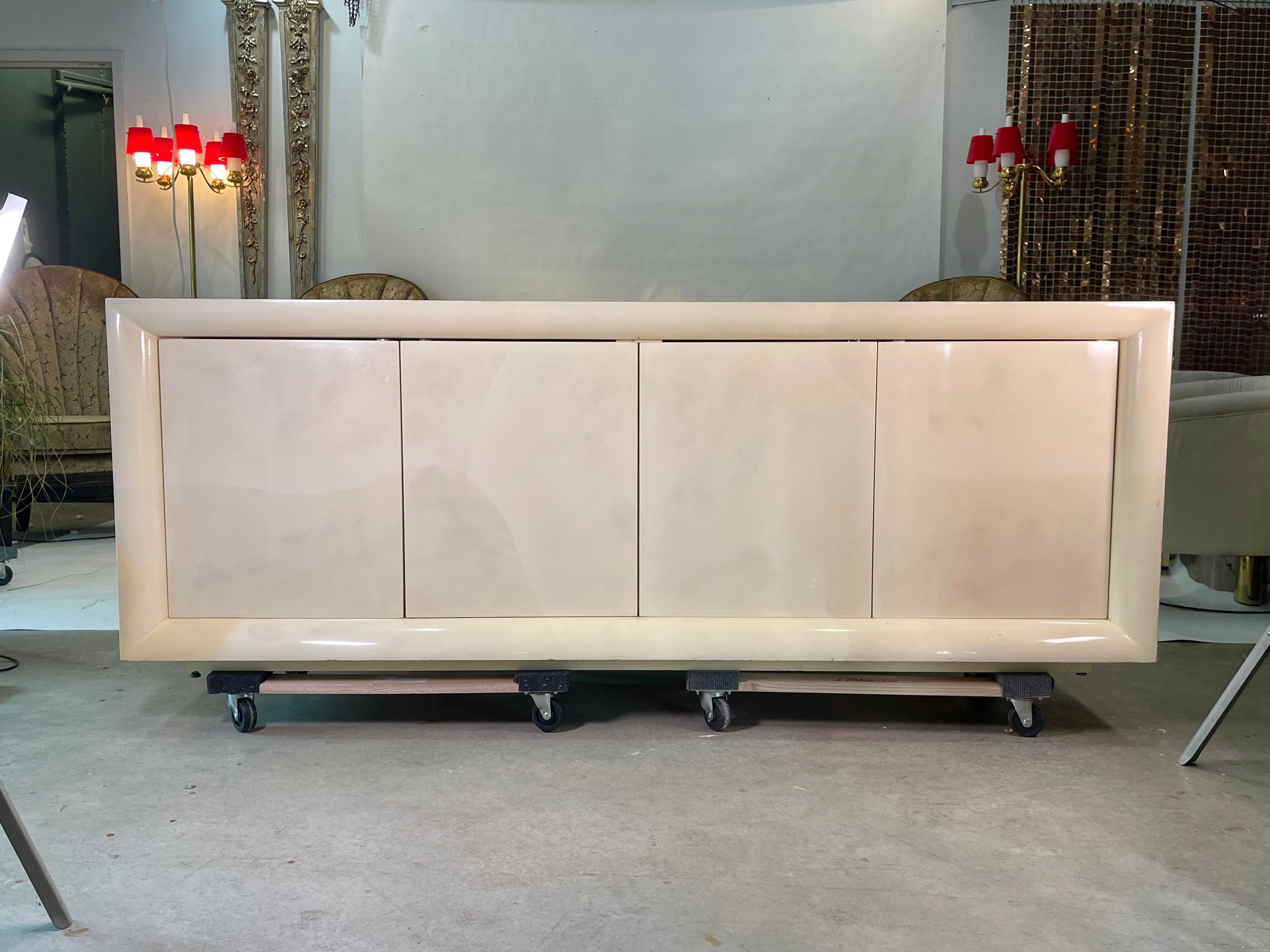 High gloss faux parchment lacquered sideboard custom made, USA, circa 1980.
Two double door interior compartments in white laminate with push-click latches.
Each compartment has a silverware drawer and a single adjustable shelf.
  