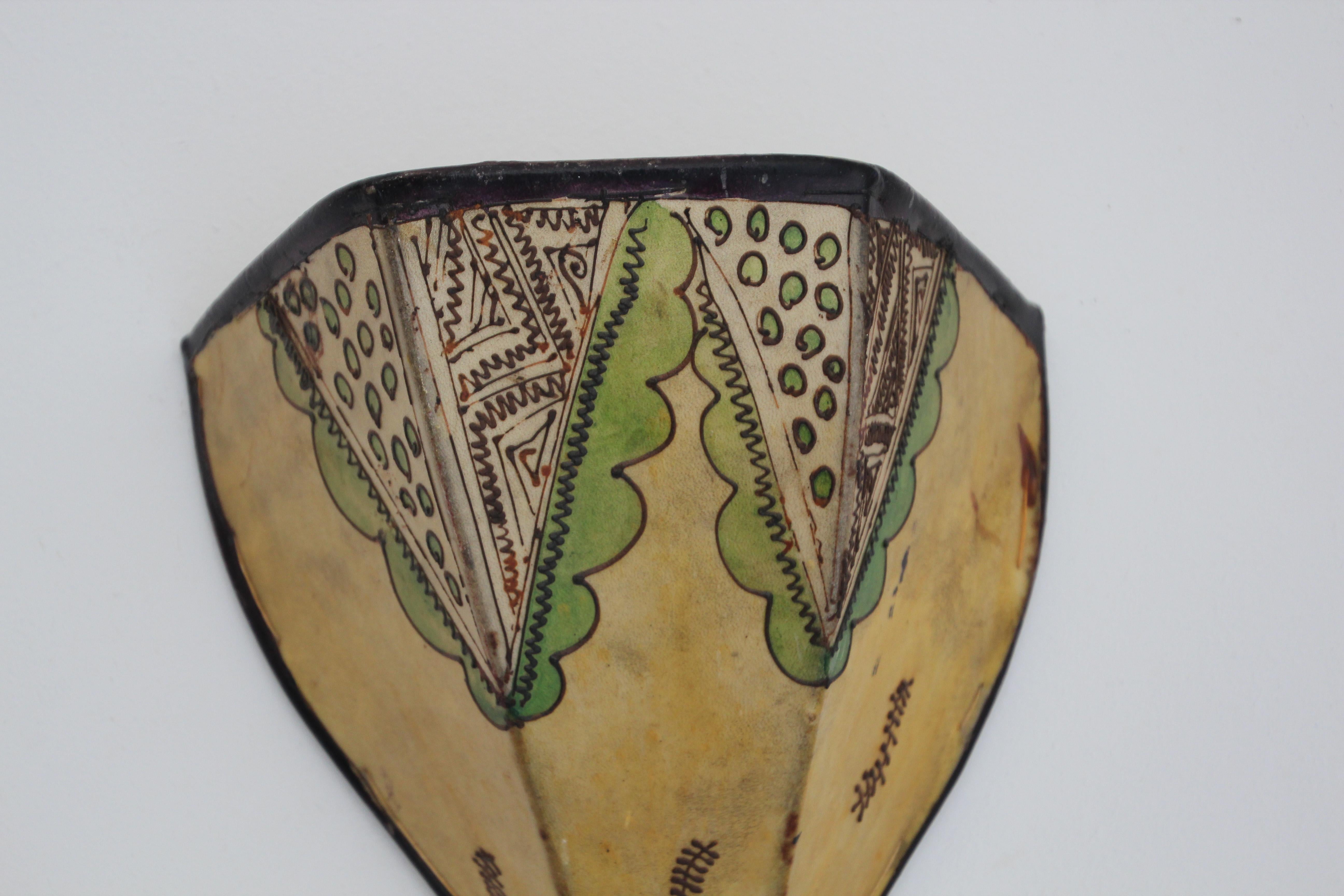 Afrikanischer Stammeskunst-Wandbehang aus Pergament mit einer großen geschwungenen Fellform, die auf Eisen genäht und von Hand bemalt ist.
Diese marokkanischen Kunstwerke können als Lampenschirm für die Wand verwendet werden.
Der mit Pergament