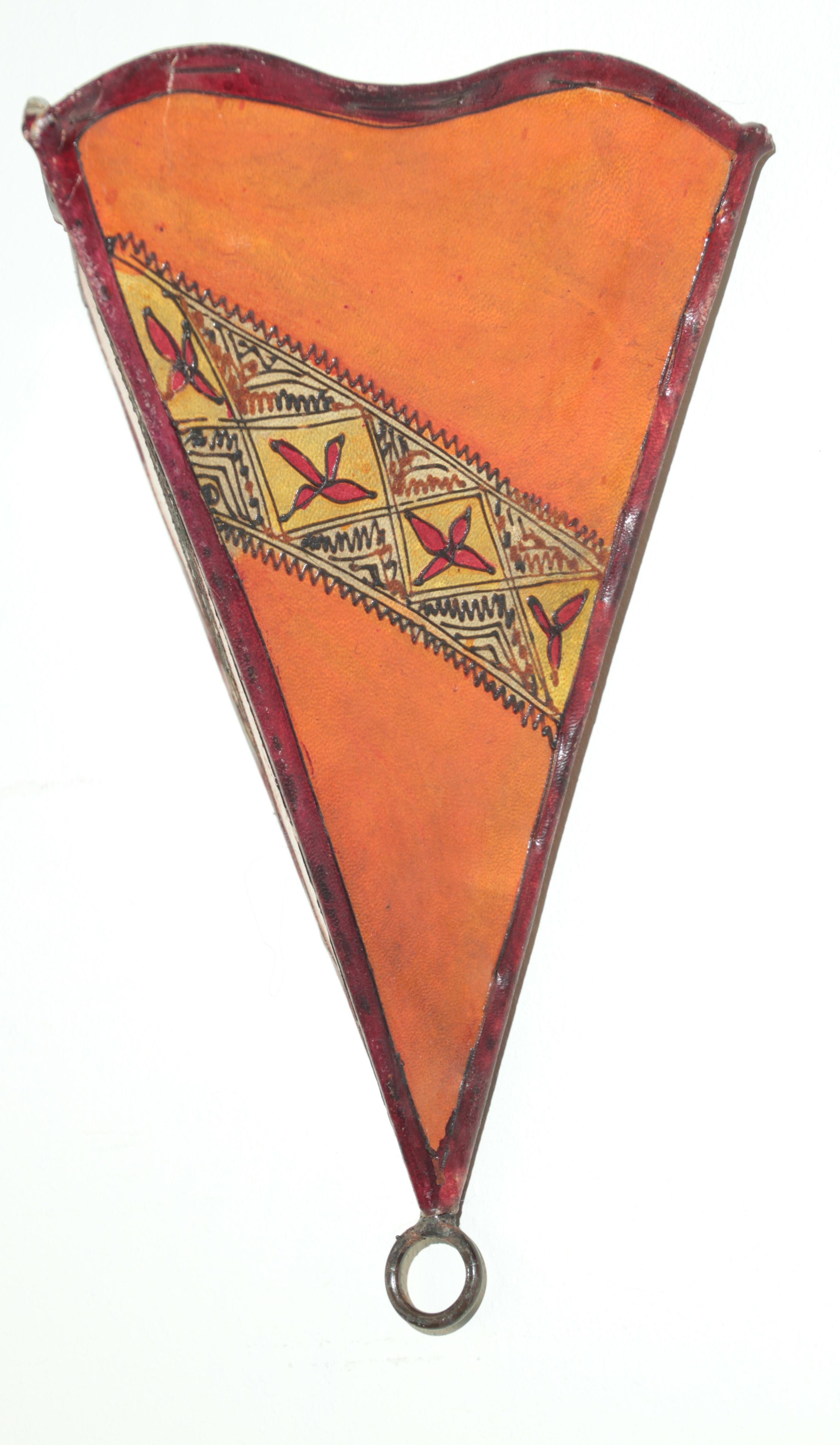 Applique murale d'art tribal africain en parchemin présentant une grande forme triangulaire en peau cousue sur du fer et une surface peinte à la main.
Ces pièces d'art marocain peuvent être utilisées comme abat-jour de lampe murale.
Le cadre en