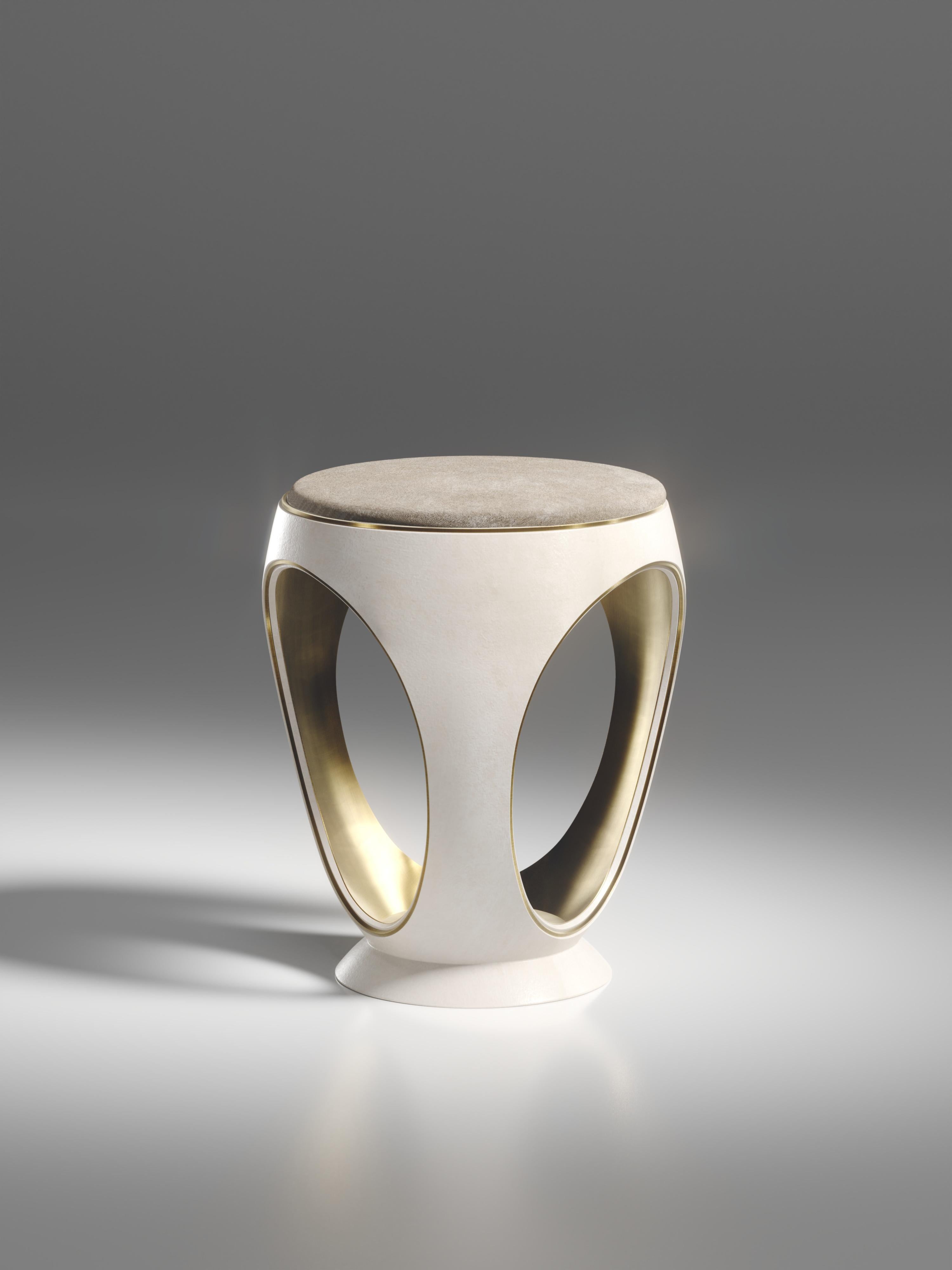 Le tabouret annulaire en parchemin crème est l'une des pièces les plus emblématiques de la Collection R&Y Augousti. De forme sculpturale, semblable à un bijou, cette pièce a été relookée avec un discret détail d'indentation en laiton patiné bronze à