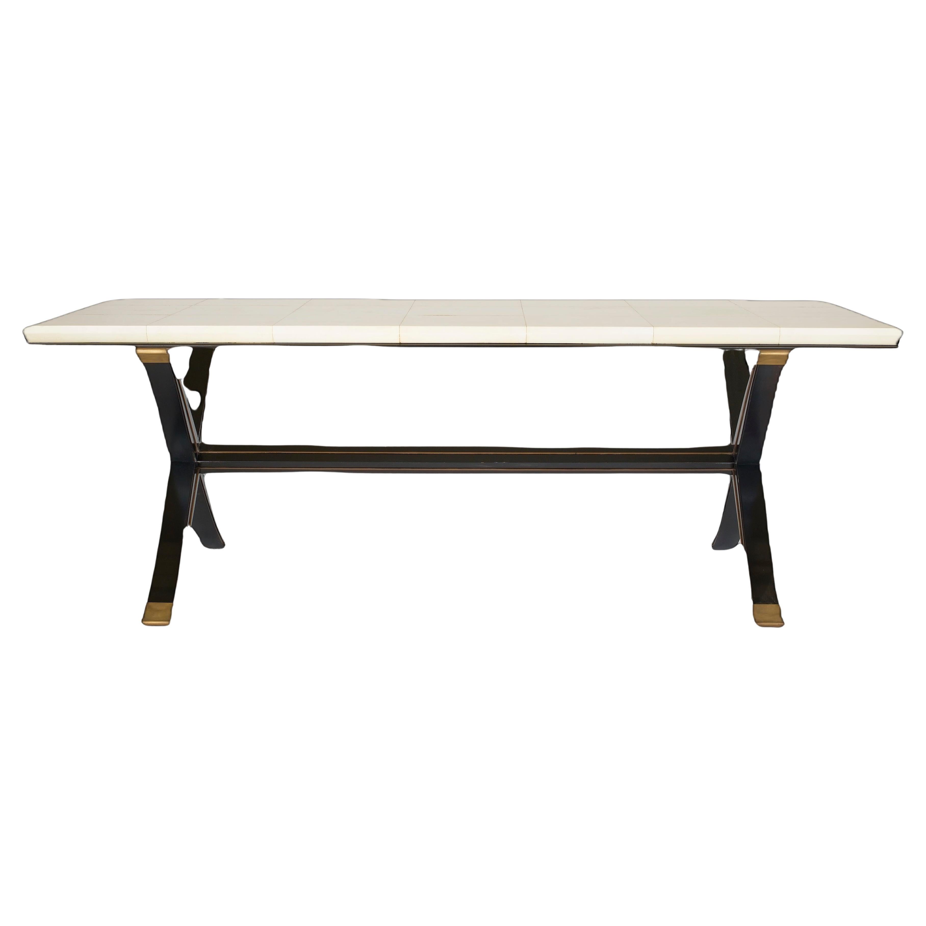 This beautiful Goatskin (Parchment) topped table is modeled after a design by André Arbus, an important French designer of the 1930s and 40s to the late 1960s. The parchment covered top sits on two black lacquered X-Formed supports with bronze