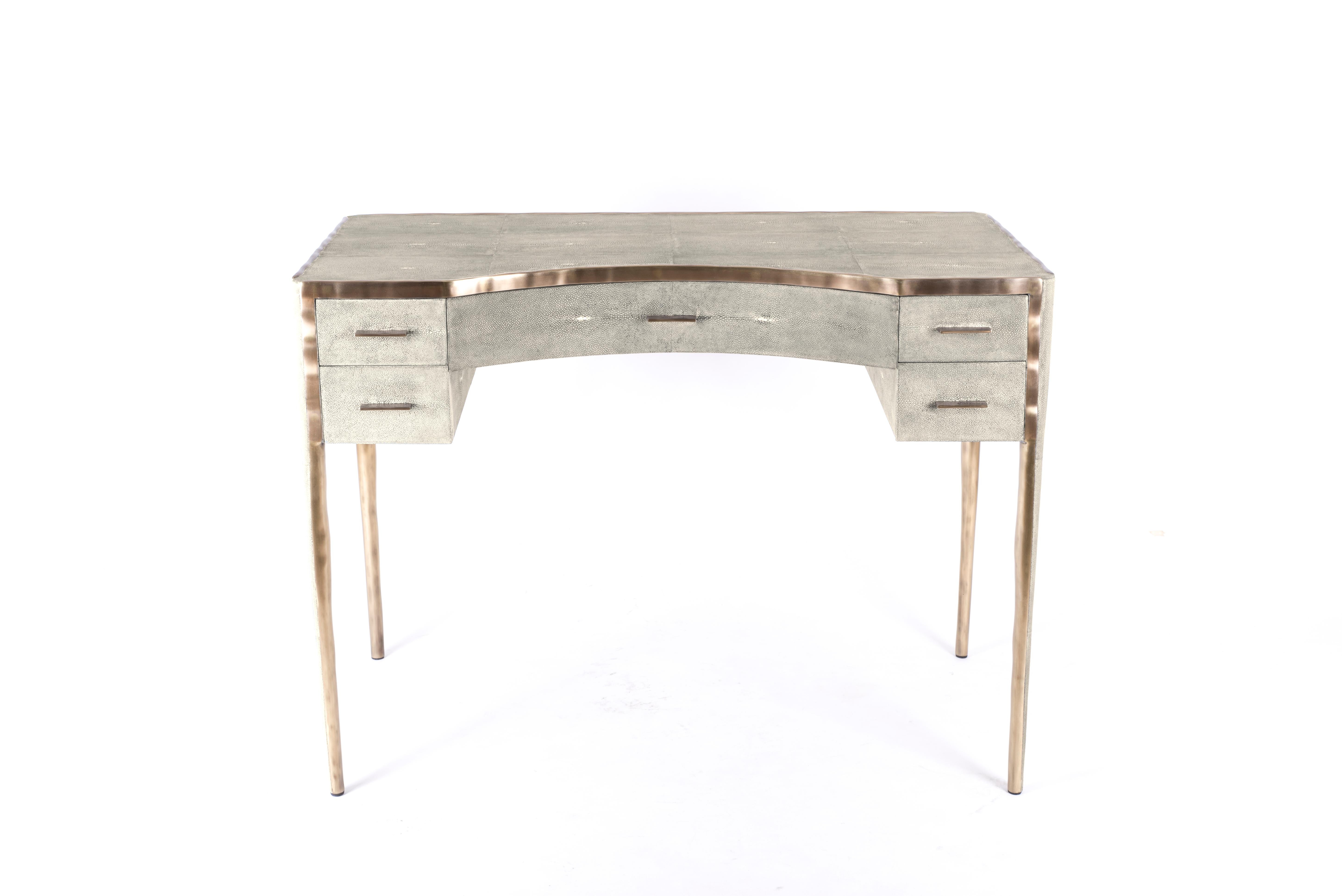 The melting vanity table's simple but elegant design, makes for an adaptable elegant piece of furniture. The cream parchment inlaid surface is framed with an irregular surface bronze-patina brass that creates the 