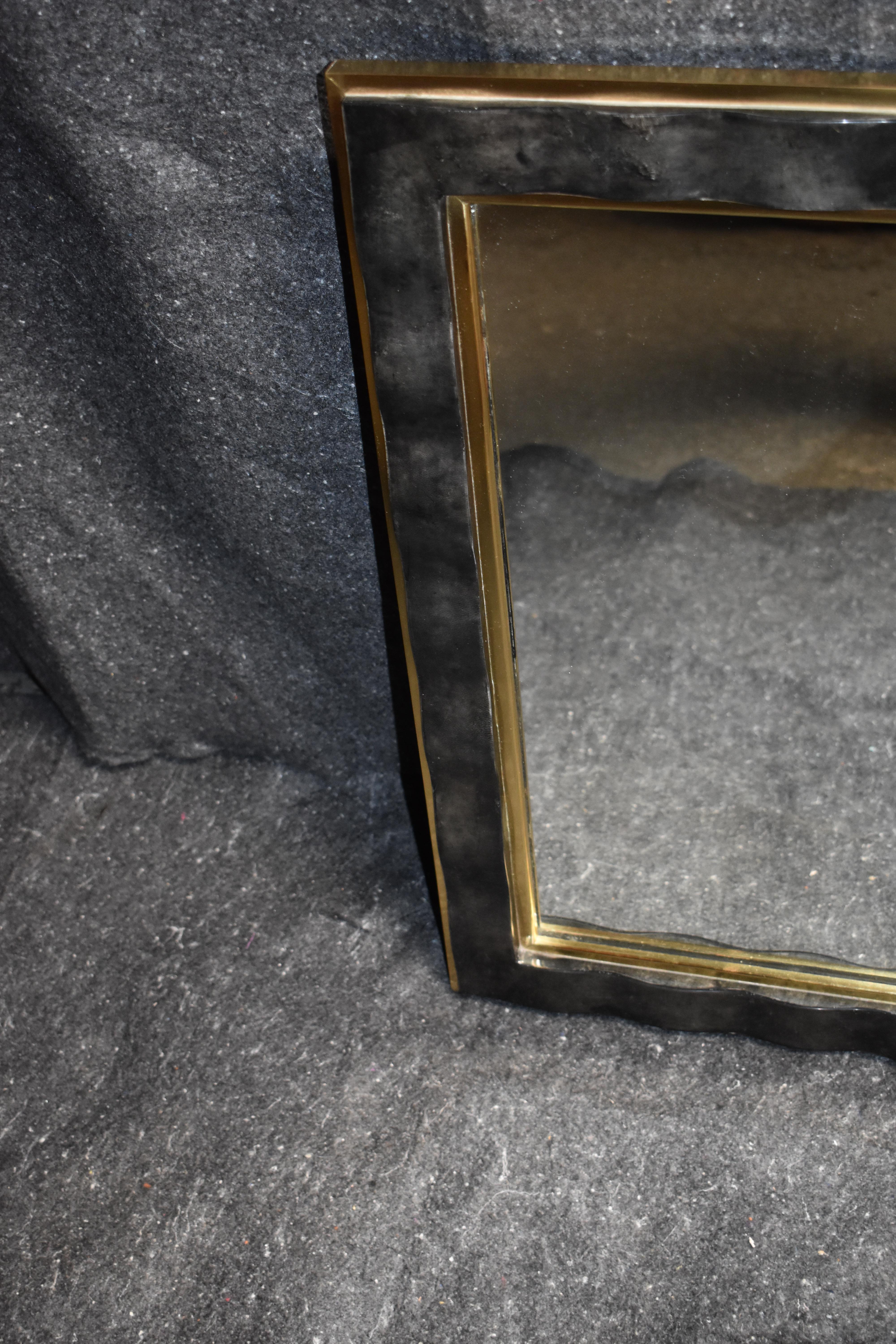Rectangular mirror cover with goatskin and brass frame and detail.
Parchment is in varying shades of light and dark charcoal. (High gloss polyester resin filled finish).