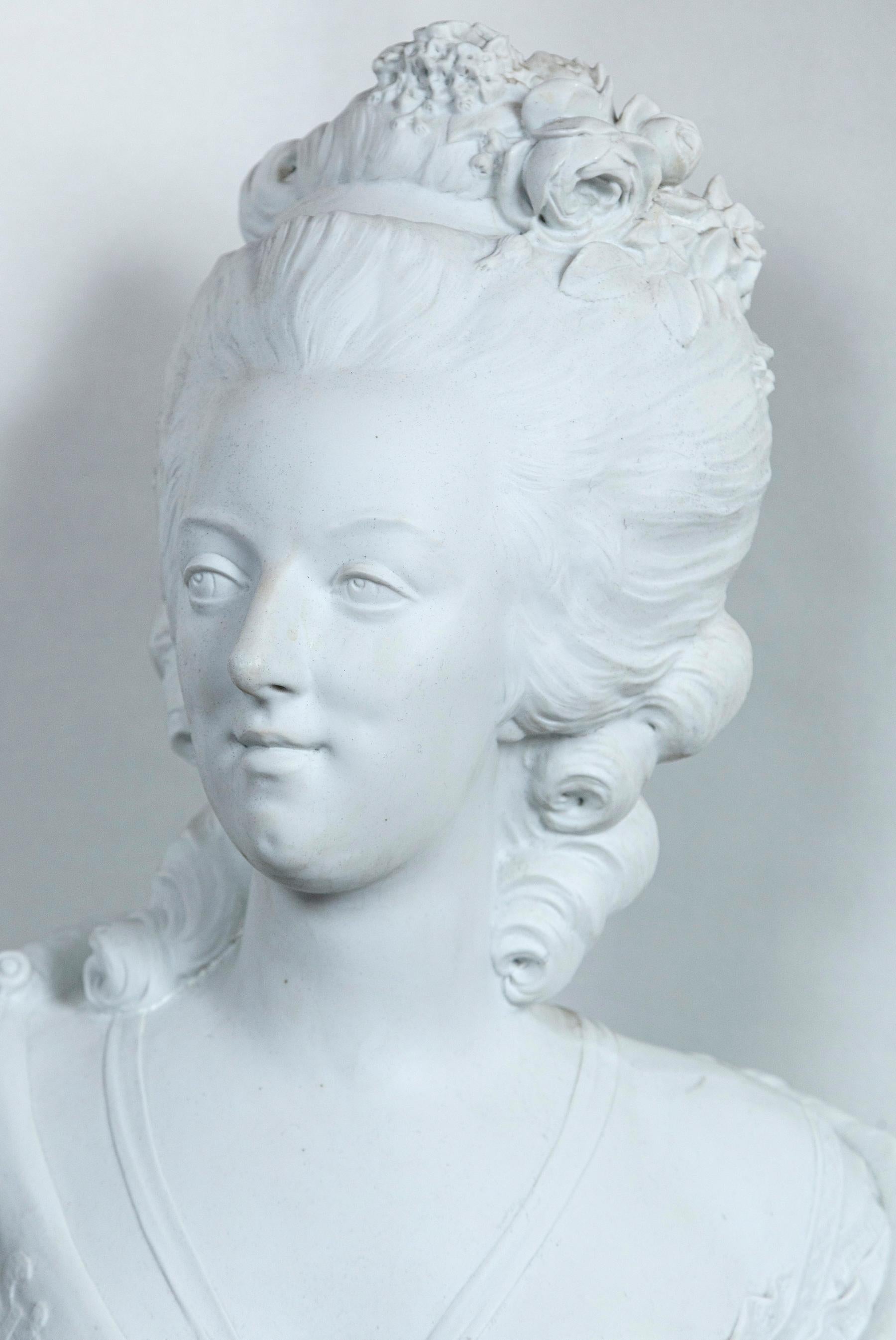 Signed across the back Lecomte (Felix Lecomte 1737-1817)
Bright white unglazed porcelain. Raised on a integral base that is 6.5 x 6.5
Her hair in the style of the late 18th century. From a ribbon around her neck hangs a profile pendant of King
