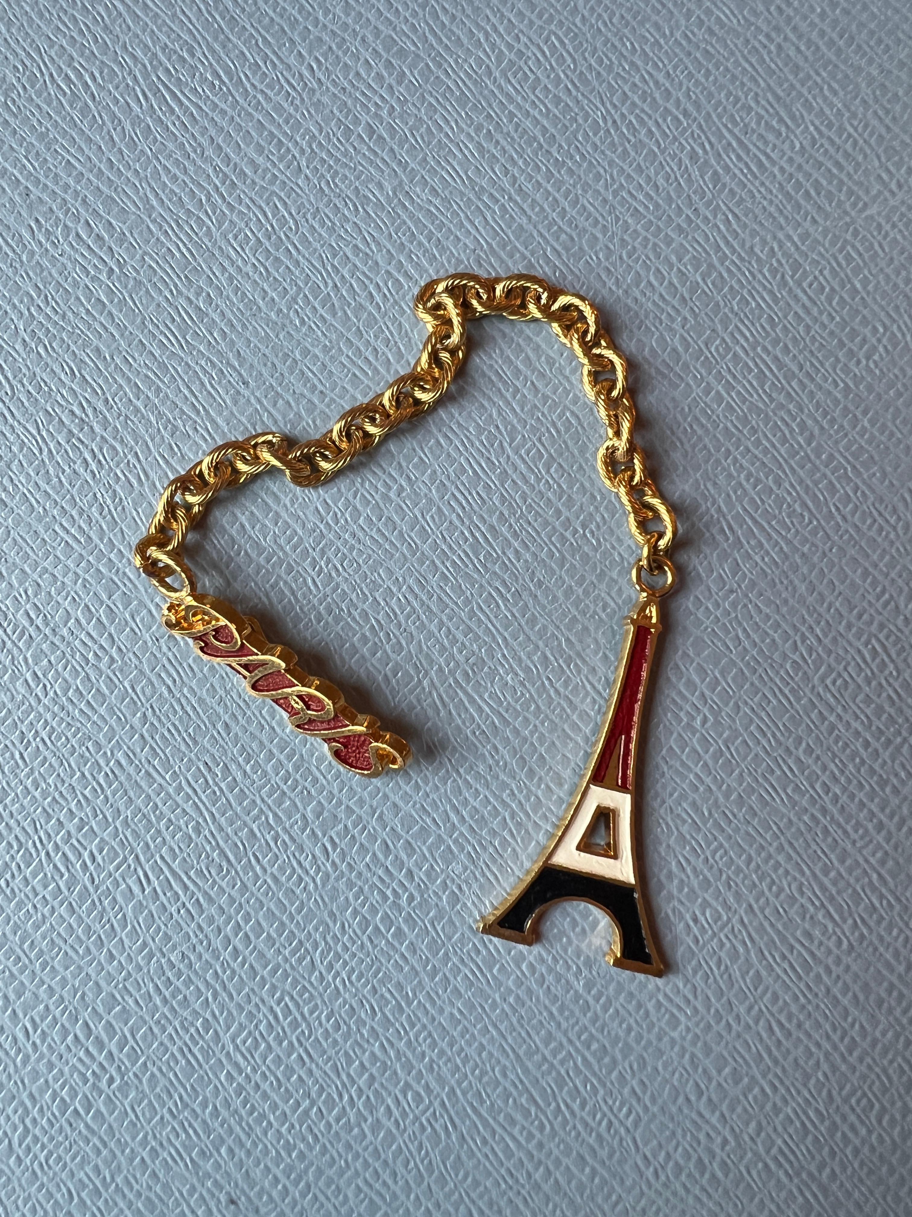 Questo orecchino a catena con Torre Eiffel di Parigi è un gioiello parigino da collezione scultoreo e di grande effetto. Realizzato in ottone placcato oro 14 carati, l'orecchino presenta un delicato charm a forma di Torre Eiffel sospeso a una