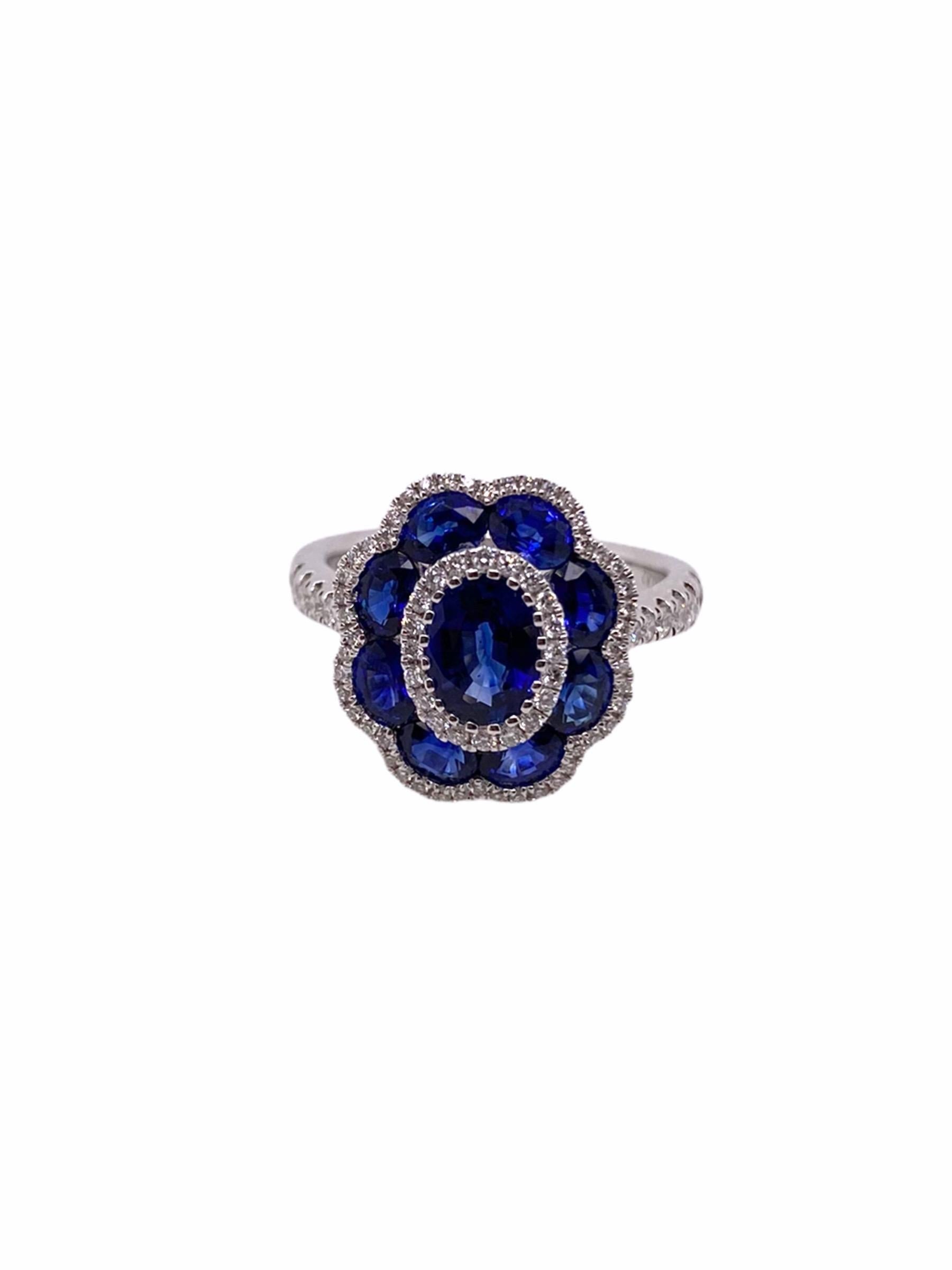 The crowning center stone of this elegant piece is a 0.82ct royal blue Oval-cut Sapphire. In it's surrounding, there are 8 Oval-cut Sapphires weighing a total of 1.64ct hand picked to match their size, cuts, and color. The ring, with the band is