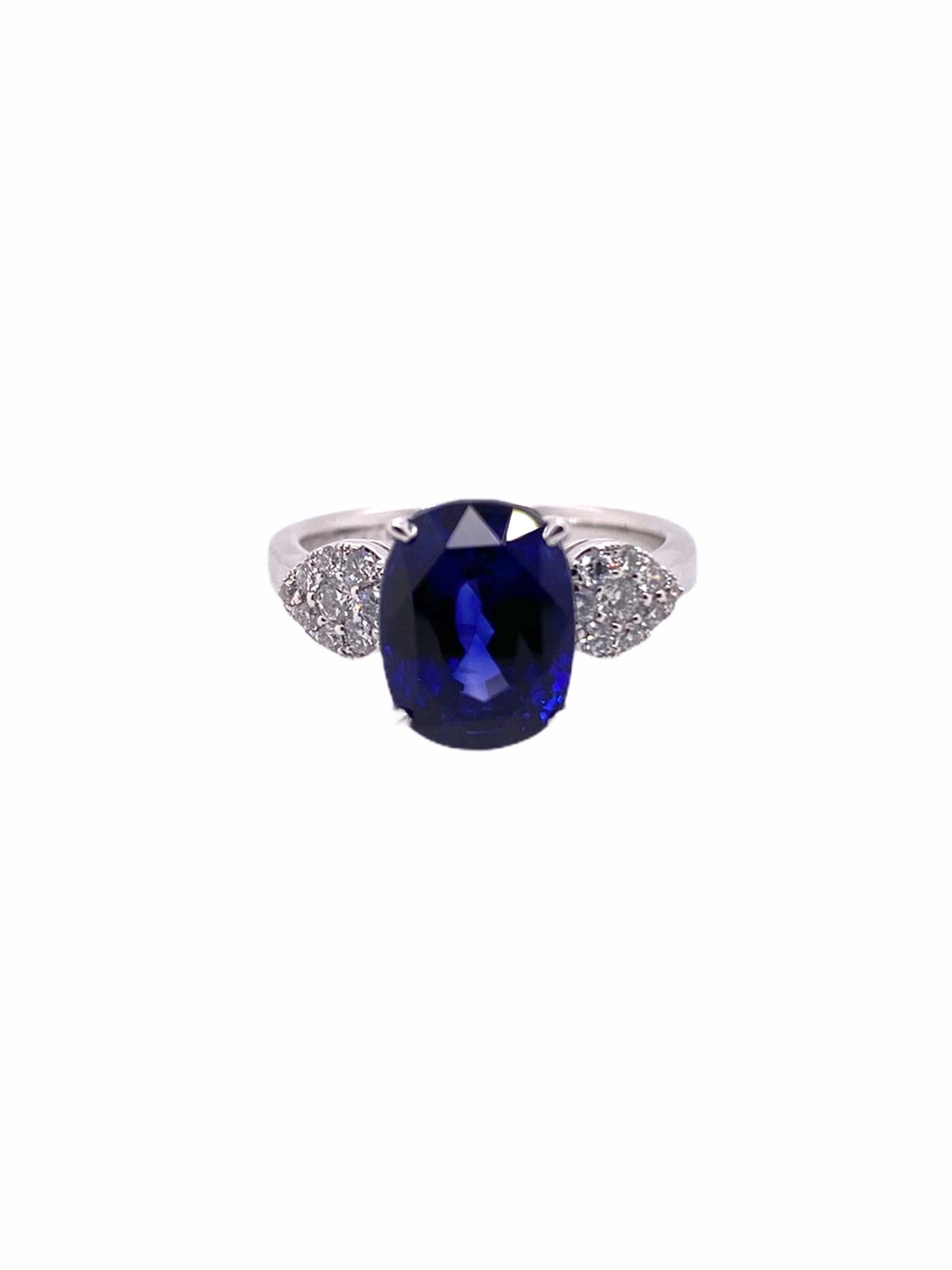 PARIS Craft House one-of-one Sapphire Diamond Ring. This majestic piece features a 5.18ct Oval-cut Blue Sapphire. The big blue stone is adorned with 12 Round Diamonds clustered on its shoulders, elegantly set on 18 Karat White Gold.

- 1 Blue