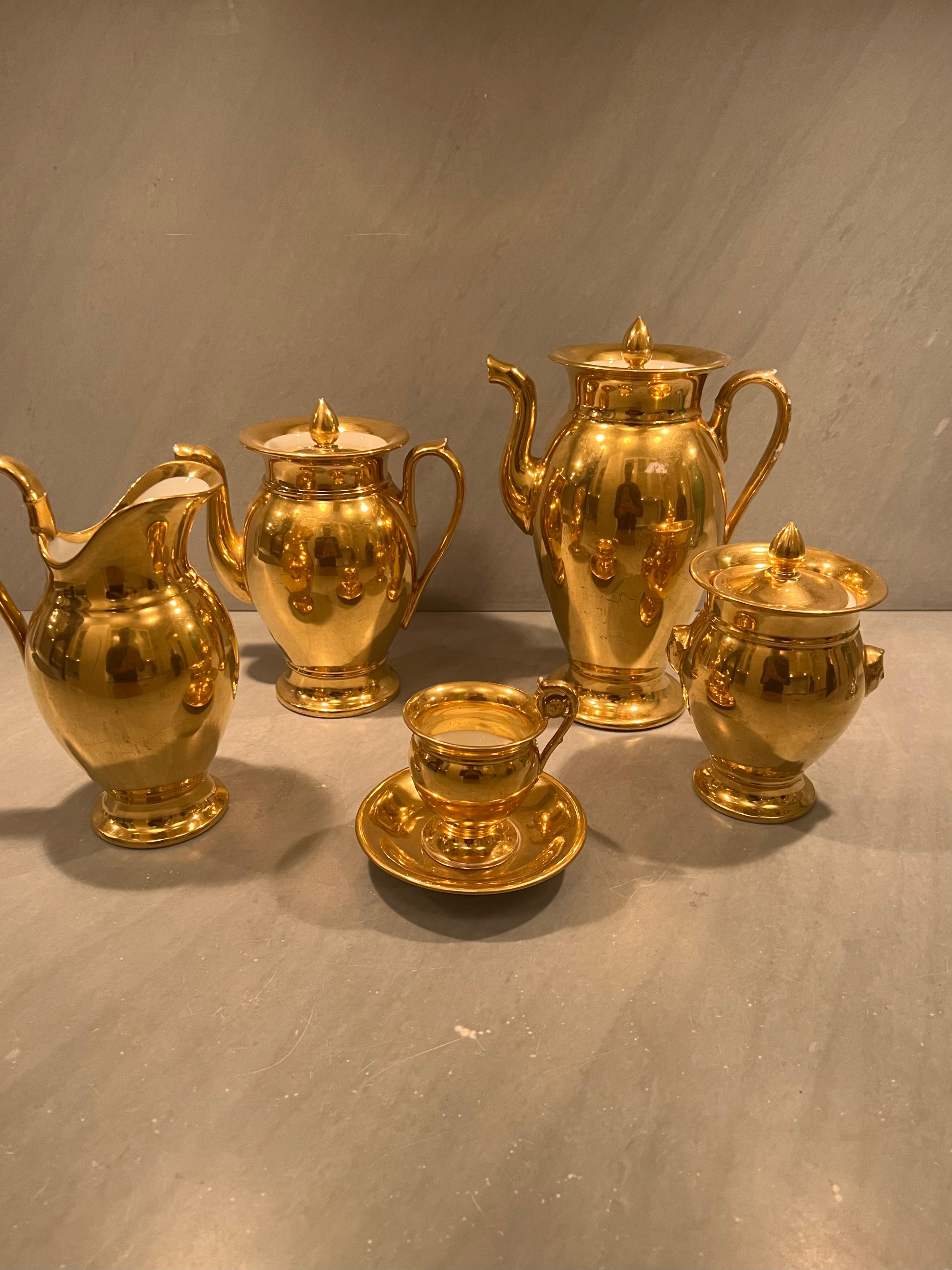 A vintage Paris Gold porcelain coffee and tea set. France, circa 1940. Unmarked. 

Includes the following 28 (twenty-eight) pieces:
1 Coffee pot
1 Tea pot
1 Creamer
1 Sugar jar
12 cups
12 saucers