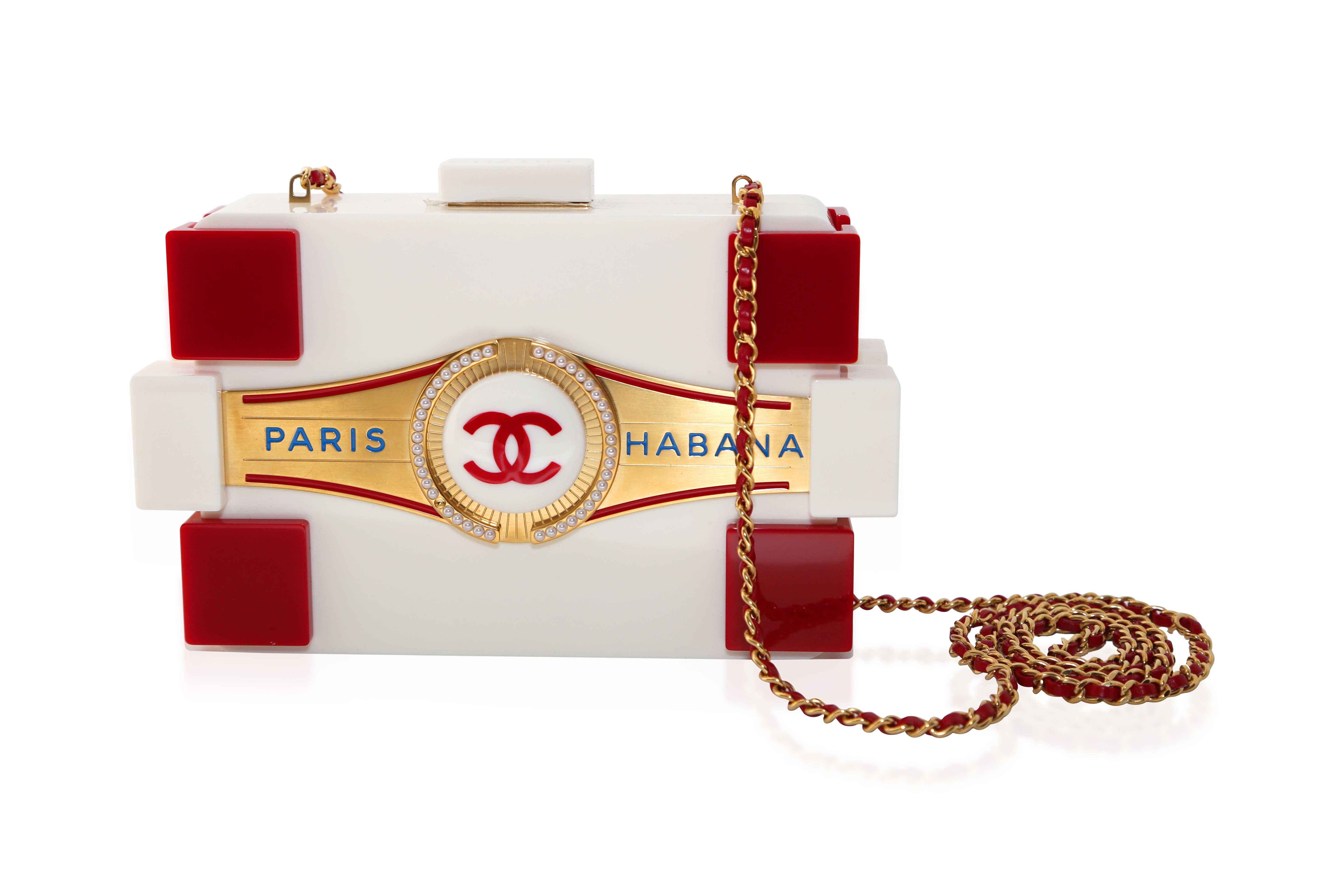 Karl Lagerfeld's lasting impact on fashion shines in this collector's edition clutch from his final runway show. Inspired by Cuba, the bag features a cigar-box design, a lucite Lego Boy Brick shape, and elegant gold and pearl details. The versatile