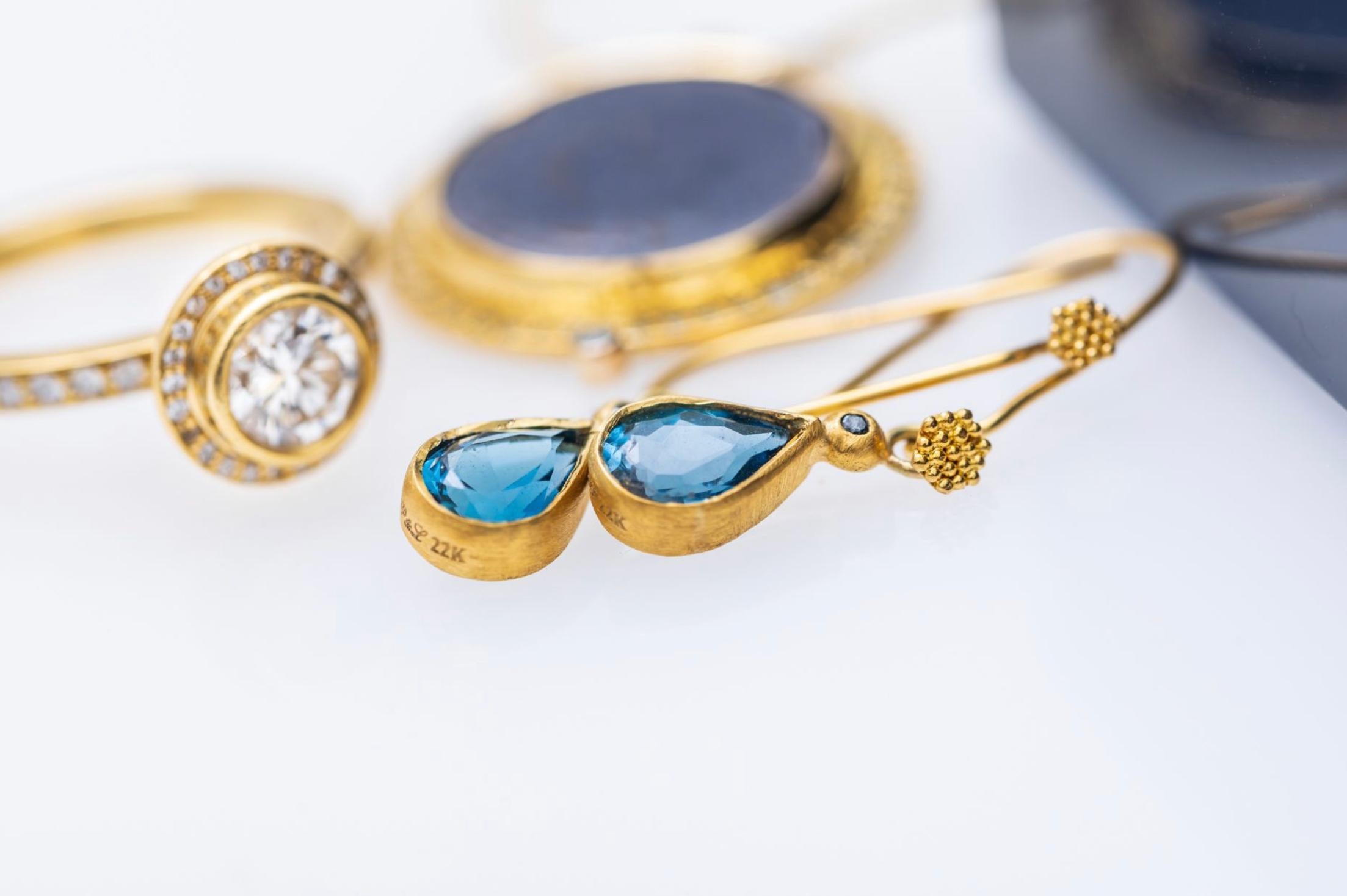 Orecchini pendenti in oro 22K a forma di pera con tormalina blu e diamante blu, unici nel loro genere e realizzati a mano, su fili d'oro 18K granulati.  La goccia del ciondolo è di 11 mm dal filo dell'orecchio. Orecchini perfetti per tutti i giorni