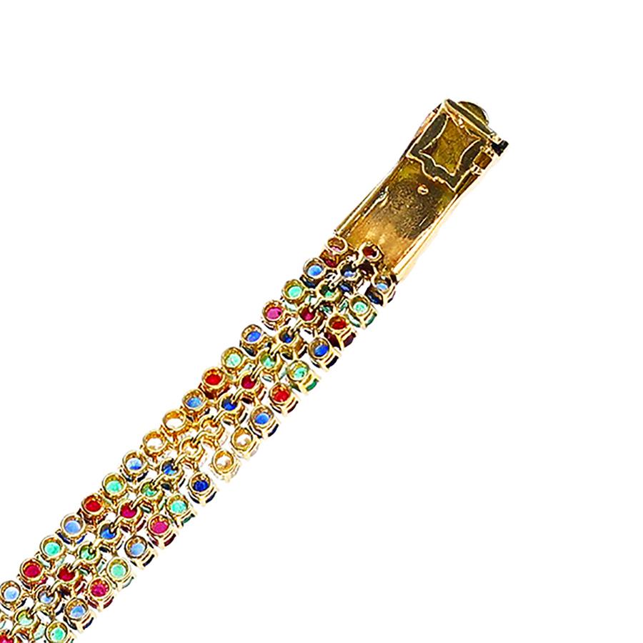 Bracelet en or 18 carats de Paris M. Gérard et André Vassort avec diamants, rubis, émeraudes et saphirs. Avec la marque de fabrique d'André Vassort. La longueur du bracelet est de 6,50 pouces. 

