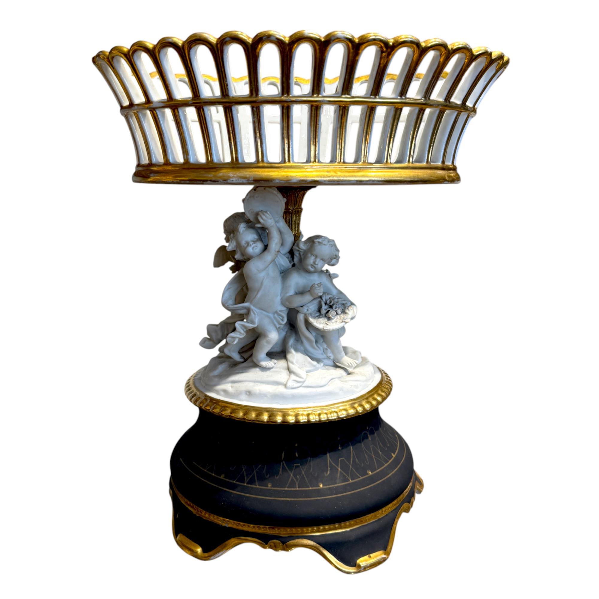 An opulent and finely crafted 19th-century French centerpiece, this piece epitomizes the elegance and artistic sophistication of the Louis XVI revival period. The openwork basket is fashioned from porcelain, delicately hand-painted and adorned with