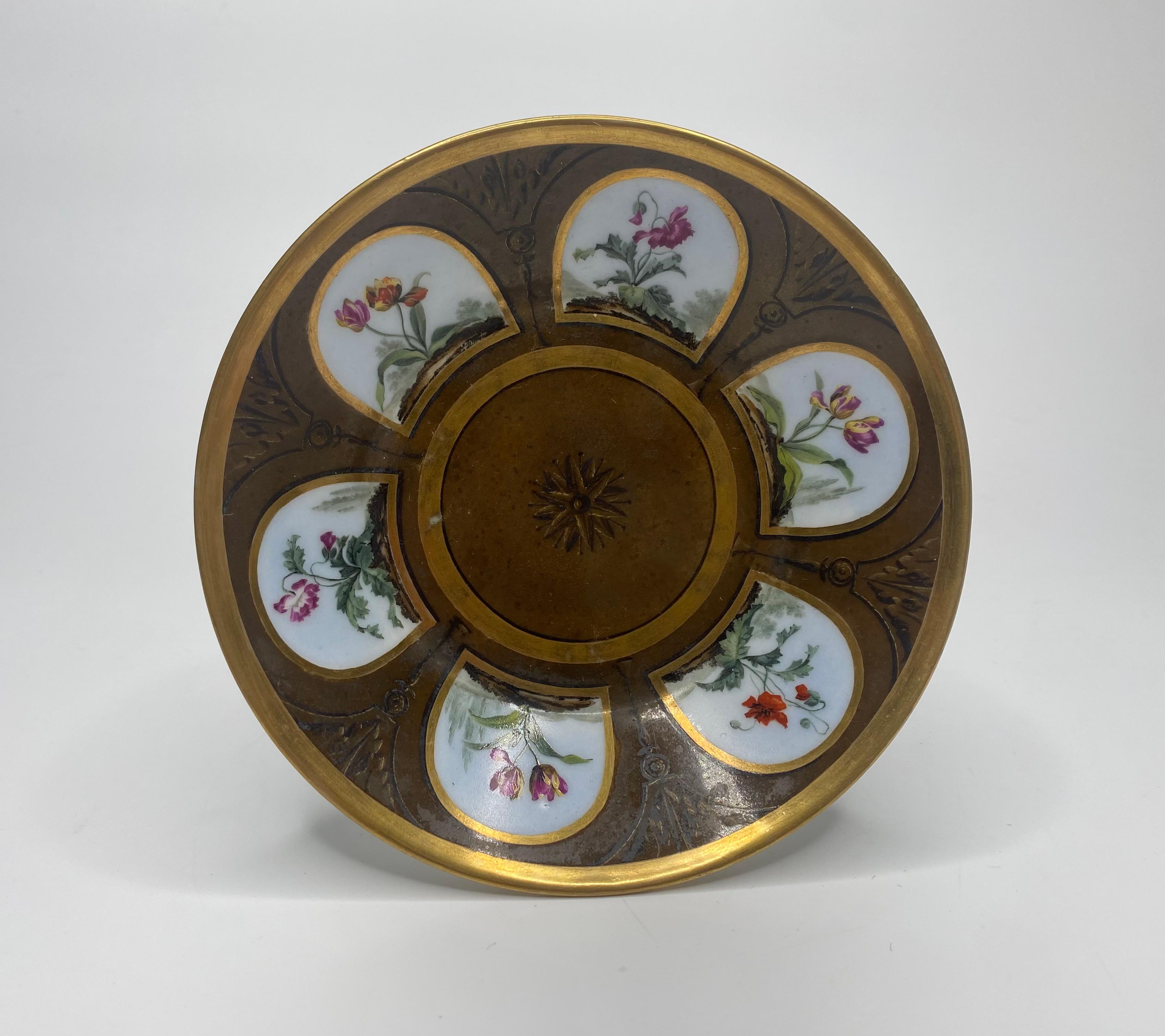 A fine Paris porcelain coffee can and saucer, possibly Dihl Et Guerhard, c. 1810. The coffee can, hand painted in the style of Gerard van Spaendonck, with panels of flowering plants, within gilt arched panels, divided by gilt and sepia architectural