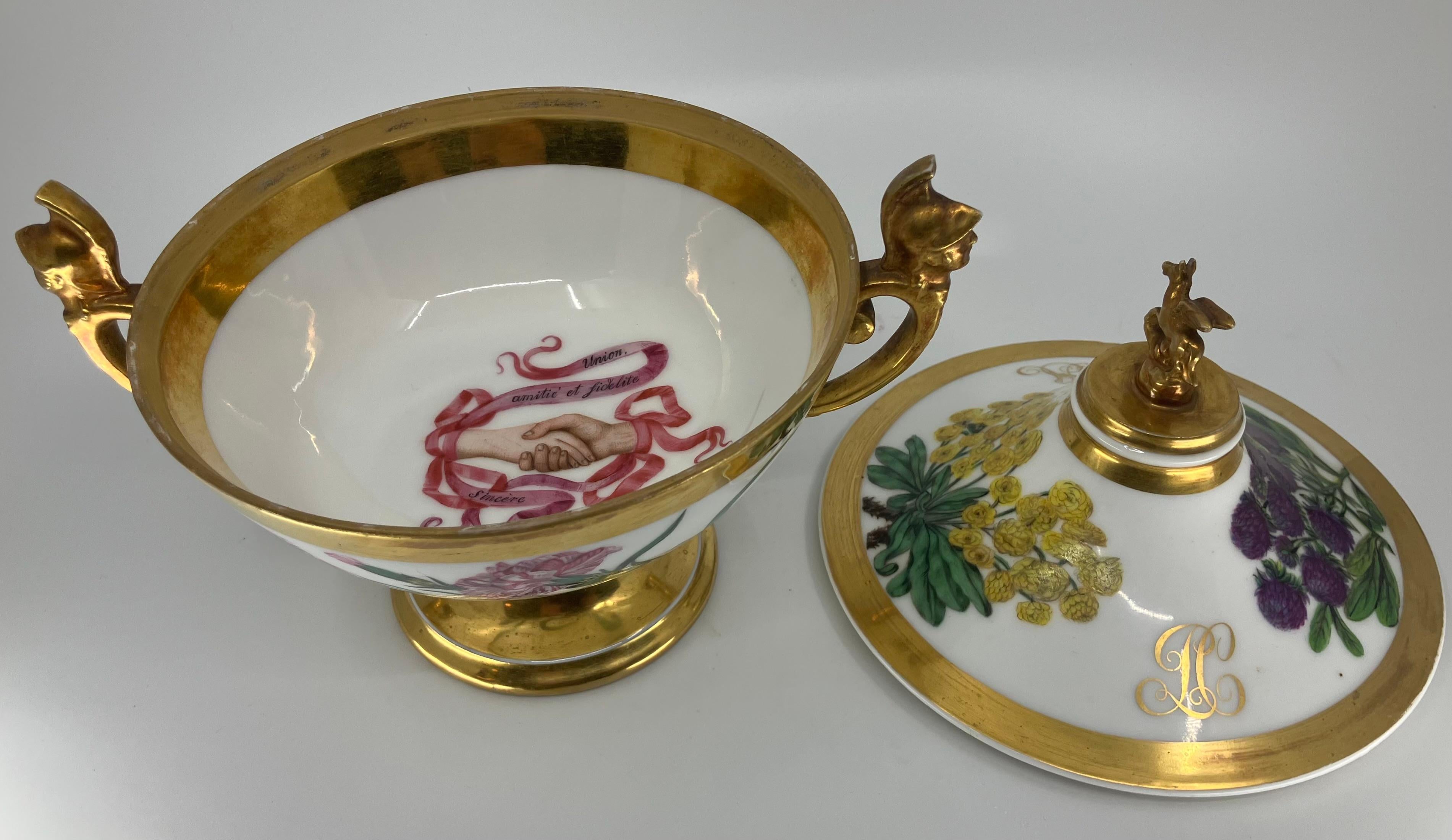 Urna nuziale in porcellana di Parigi con fiori. Zuppiera per matrimoni Paris Piatto di presentazione con coperchio e manico in porcellana dorata con manici a maschera di soldato, finalino a forma di pegaso e base interamente dorata che sostiene una
