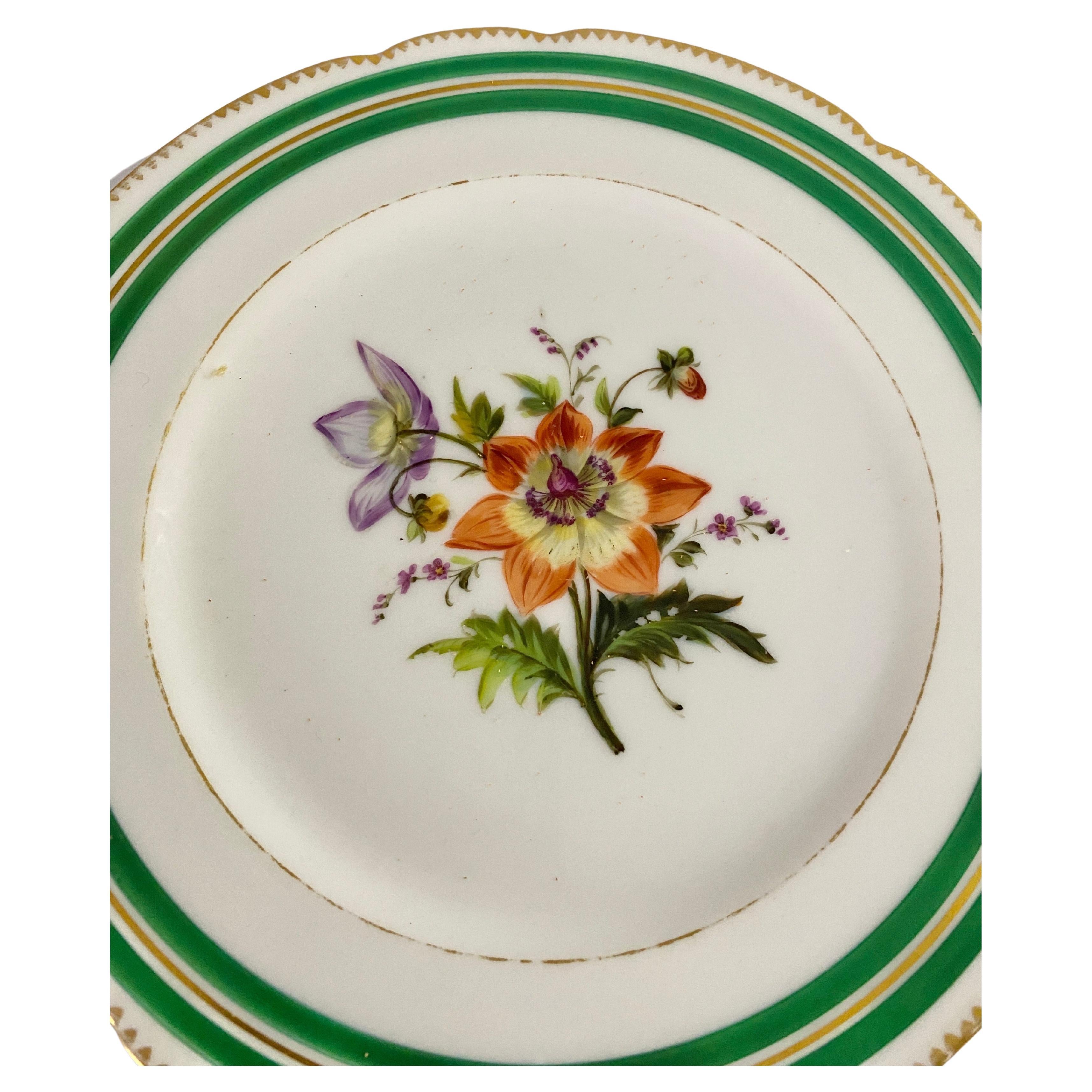 Paris porcelain plate Circa 1830. It is painted with a large spray of flowers, between gilt lines. The comor are green and gilt. It has been made in France.