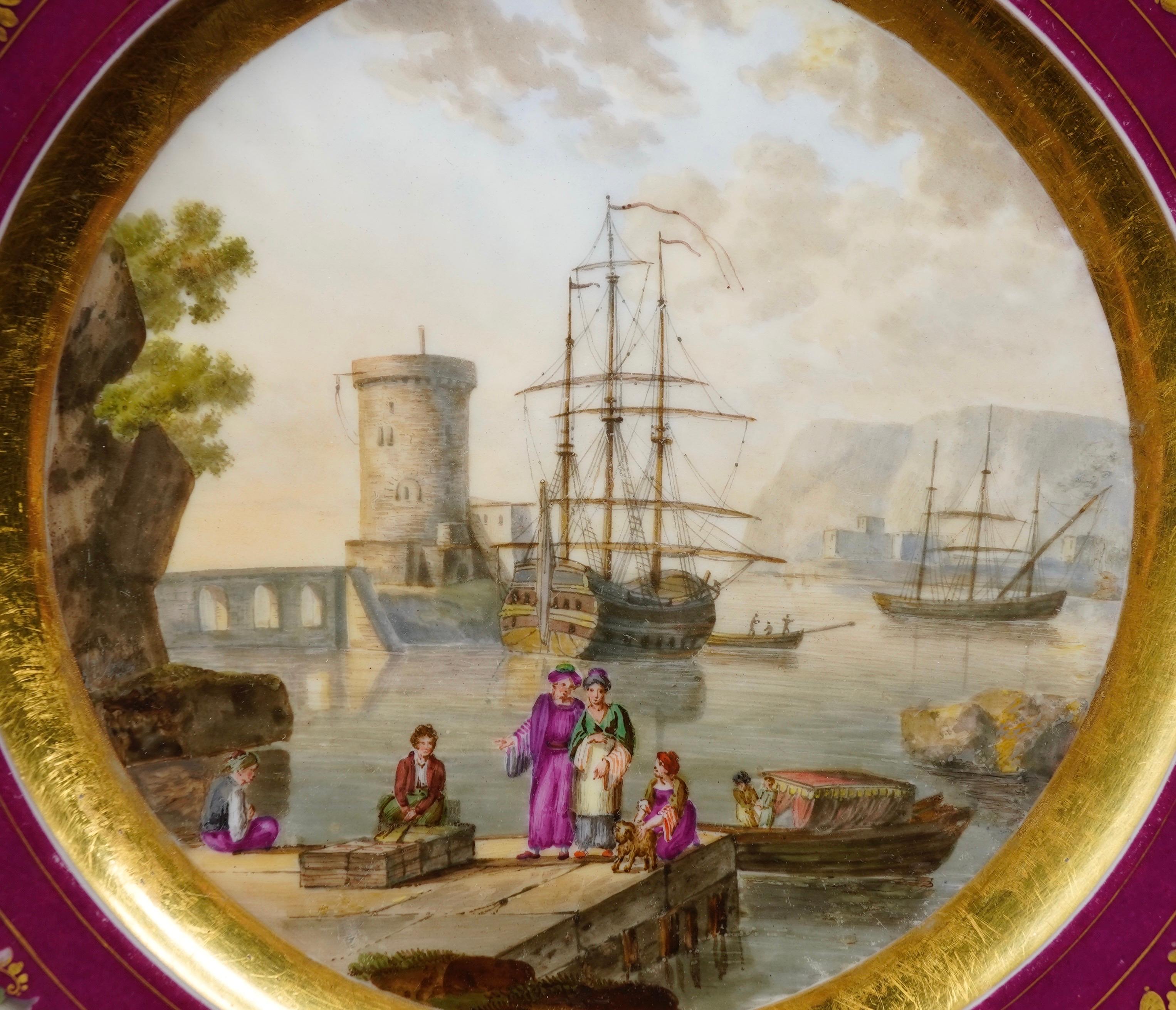 Paris Porcelain plate with superb Harbour scene, after Claude Lorrain, with figures on a quayside, ships at anchor by a circular tower, a dramatic coast and distant headland beneath a dusky sky, within a wide gold band and rim with tooled gold and