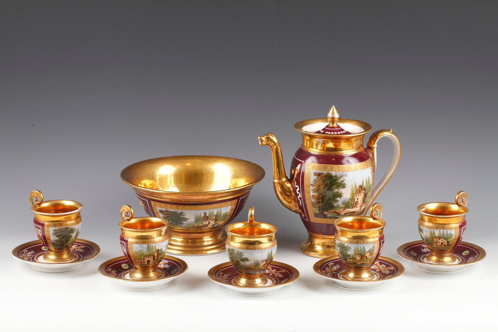 Charming Restauration style Paris porcelain tea set with red and gold Amati background, composed of a teapot, five cups with winding handle and their saucer, and a bowl. This set, lined with gold inside, is decorated with medallions representing