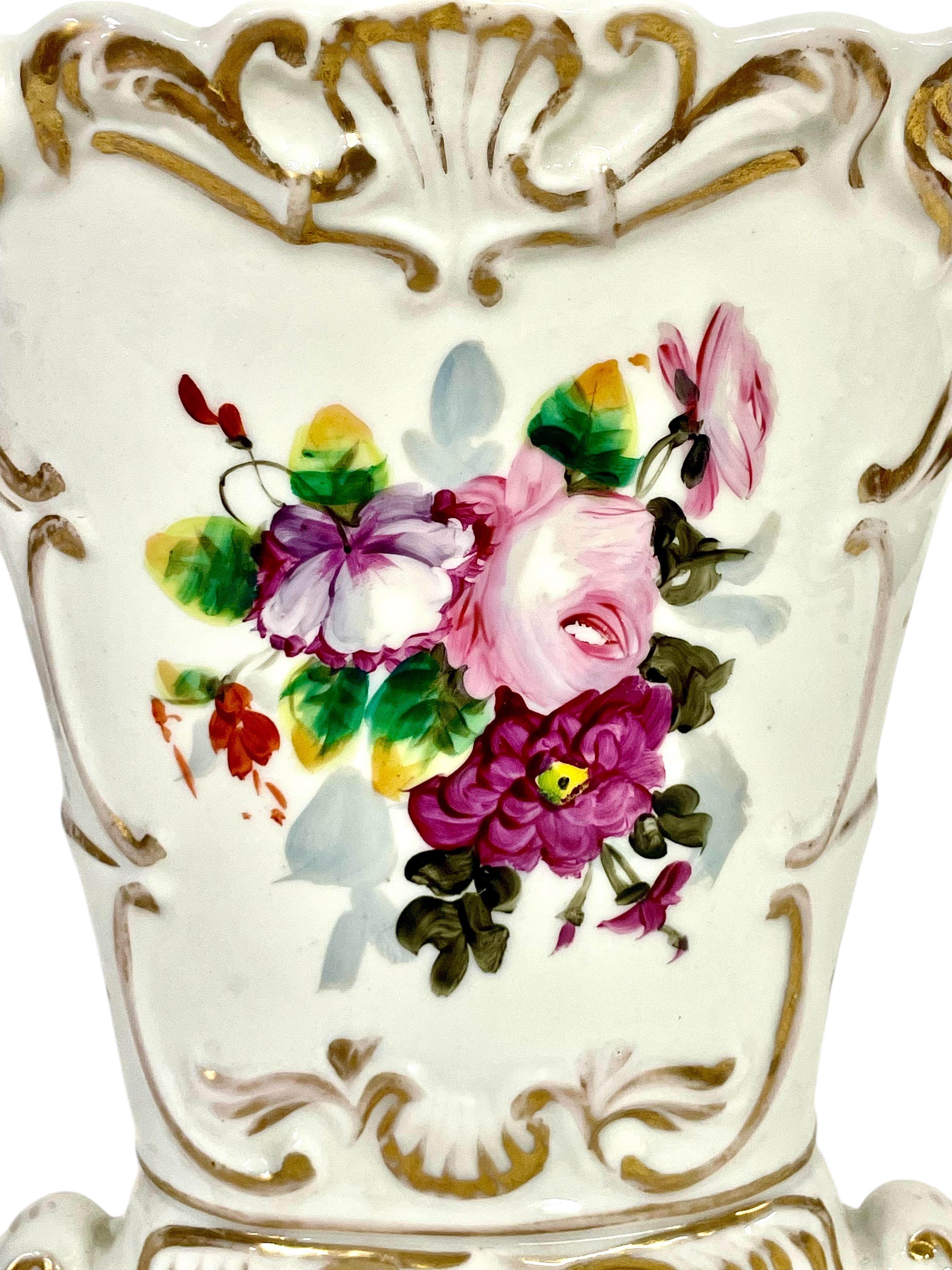 Questo grazioso vaso in porcellana di Paris risale al XIX secolo e presenta un bellissimo disegno floreale smaltato di fiori di campo, circondato da modanature in stile rococò impreziosite da dorature applicate a mano. Realizzato con una forma