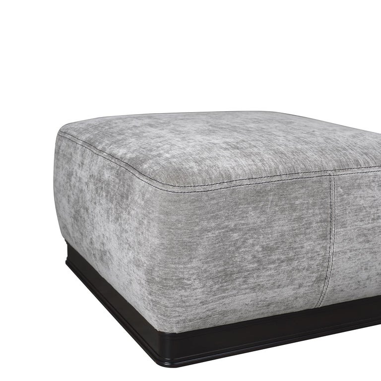 Put your feet up after a long day on the Paris Pouff, offering a harmonious fusion of traditional and modern styling. A black solid wood base with classic round feet and contoured detailing is paired with grey chenille upholstery: a versatile fabric